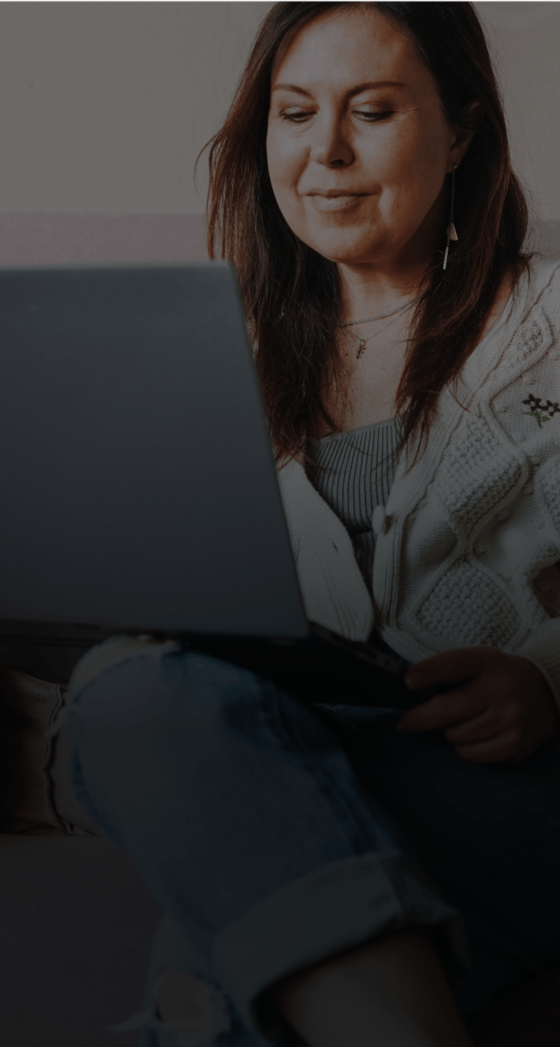 woman on a couch looking at computer