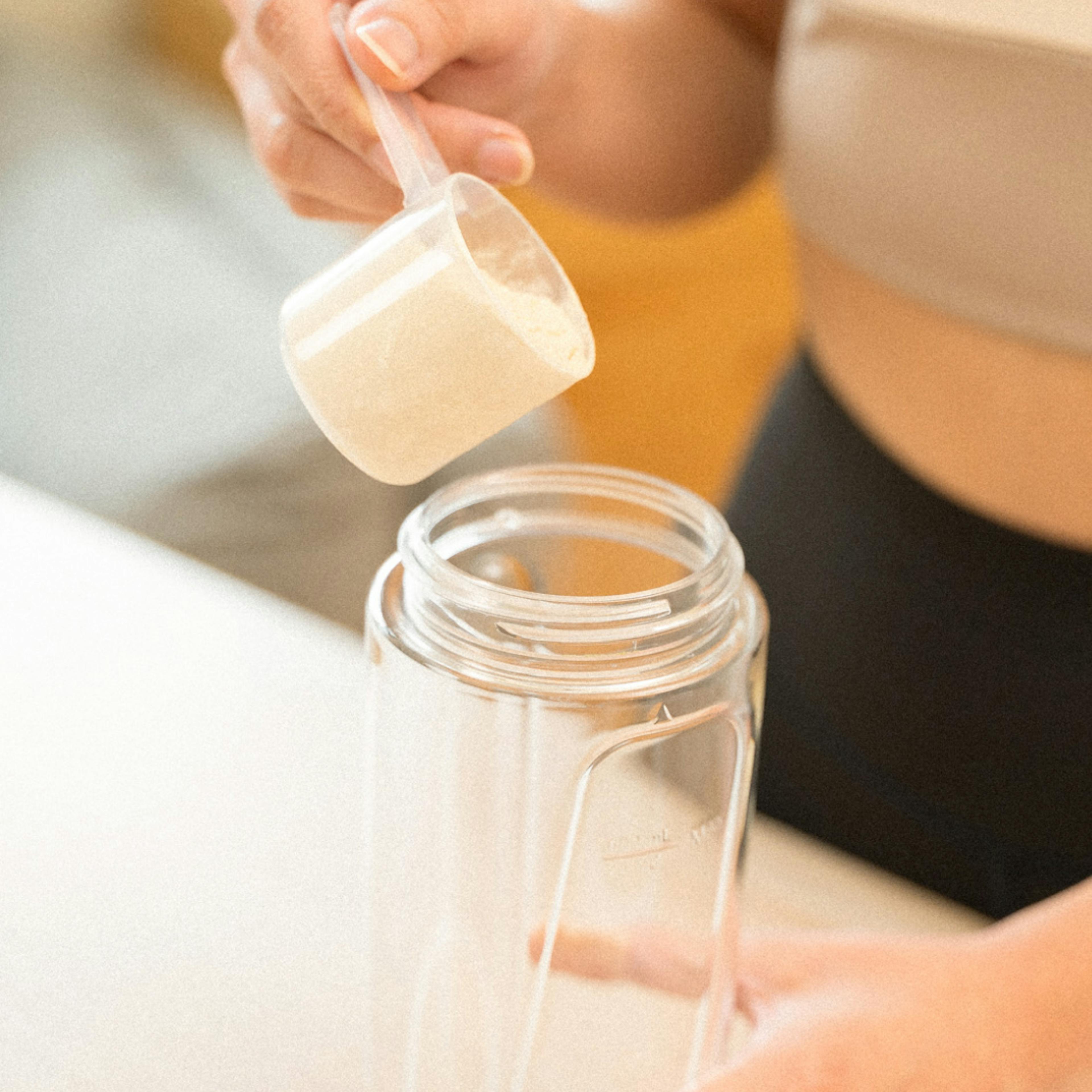 woman pouring powder into a cup