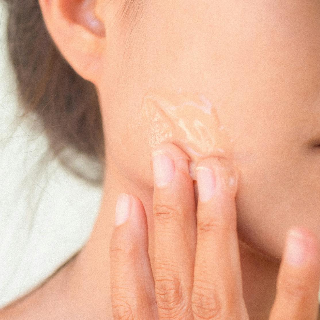 perimenopausal woman rubbing tretinoin gel on her face