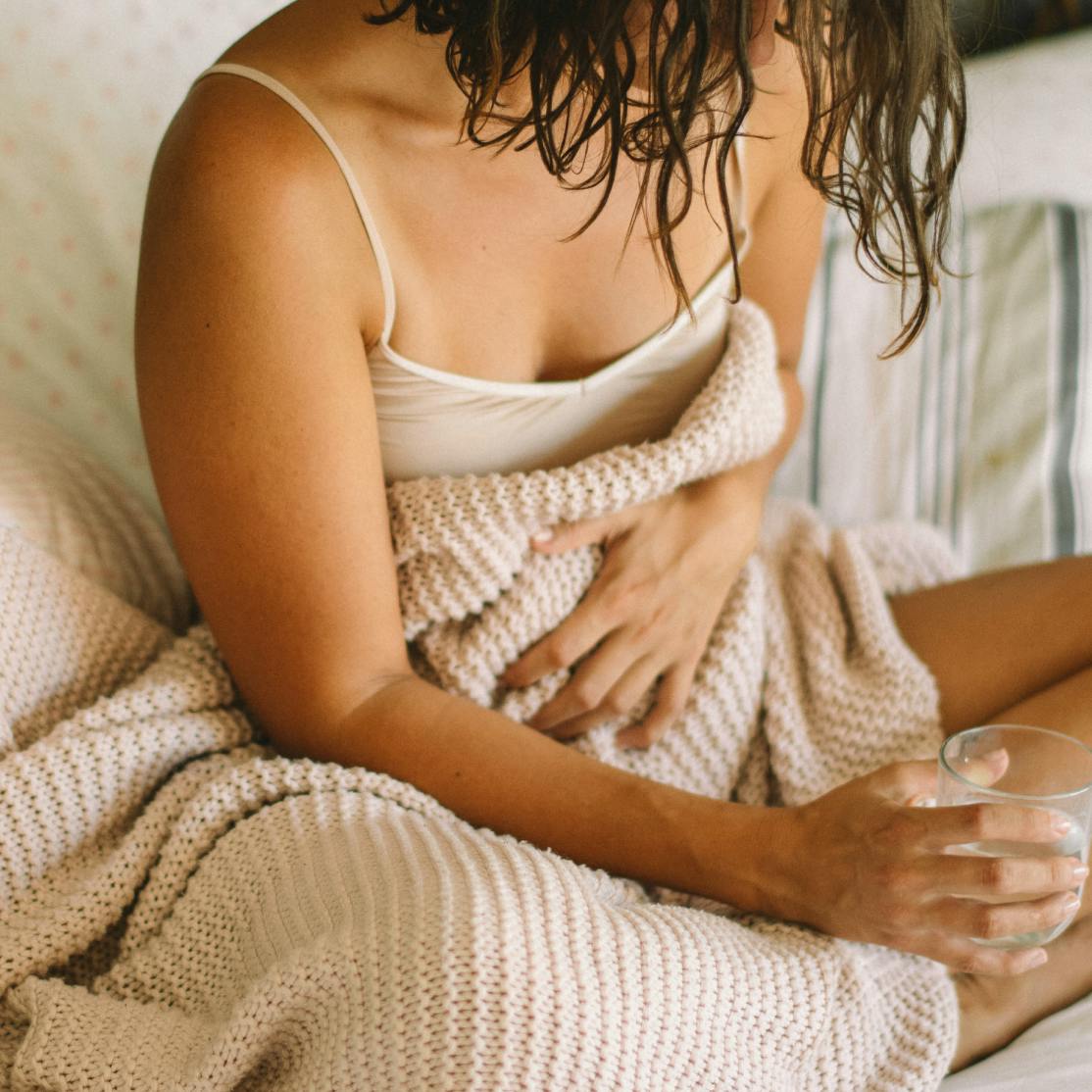 Woman after hysterectomy in perimenopause, clutching blanket