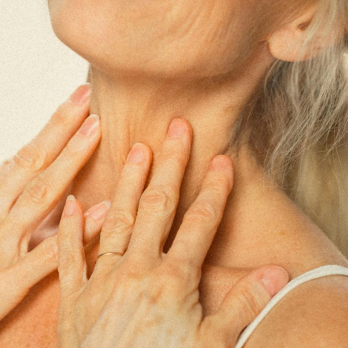 Menopausal woman touching neck wrinkles