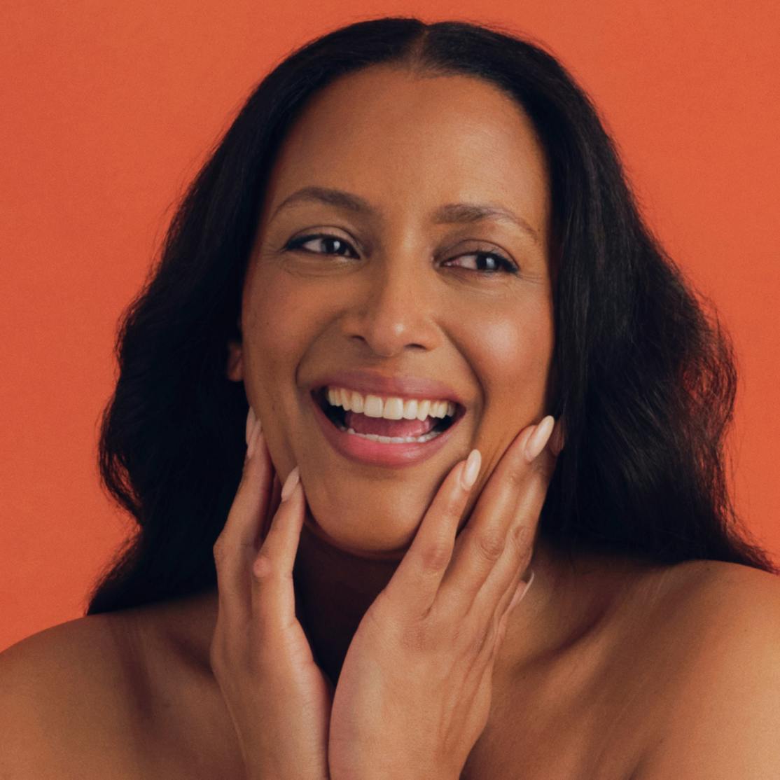 woman smiling touching her face