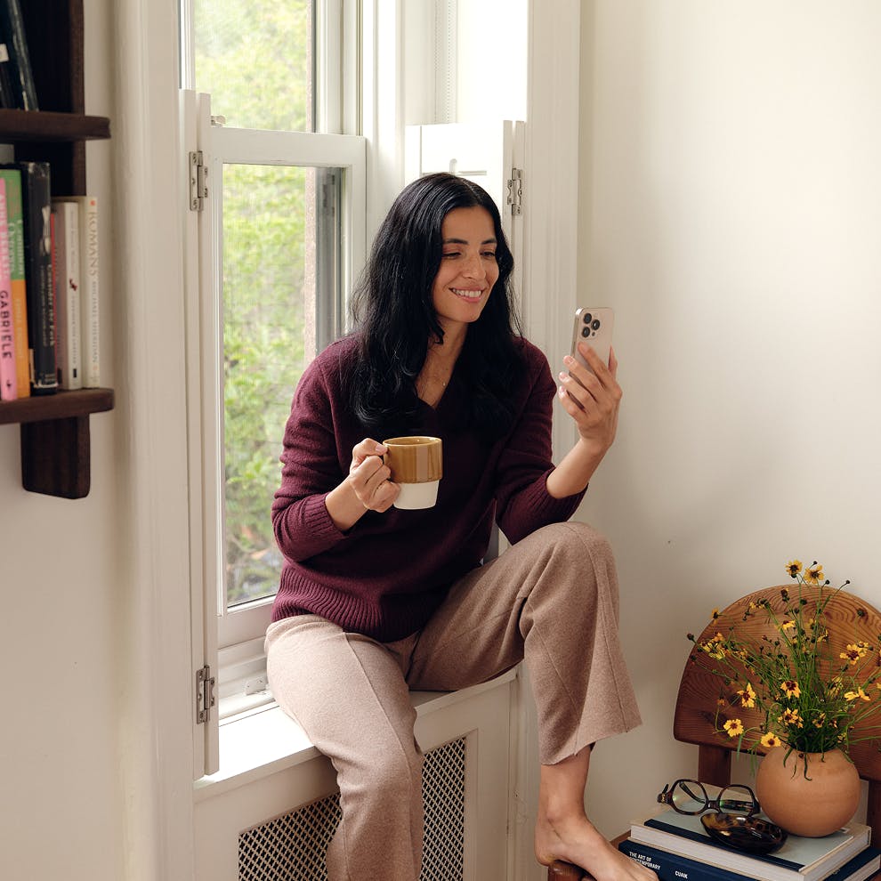 woman smiling looking at her phone