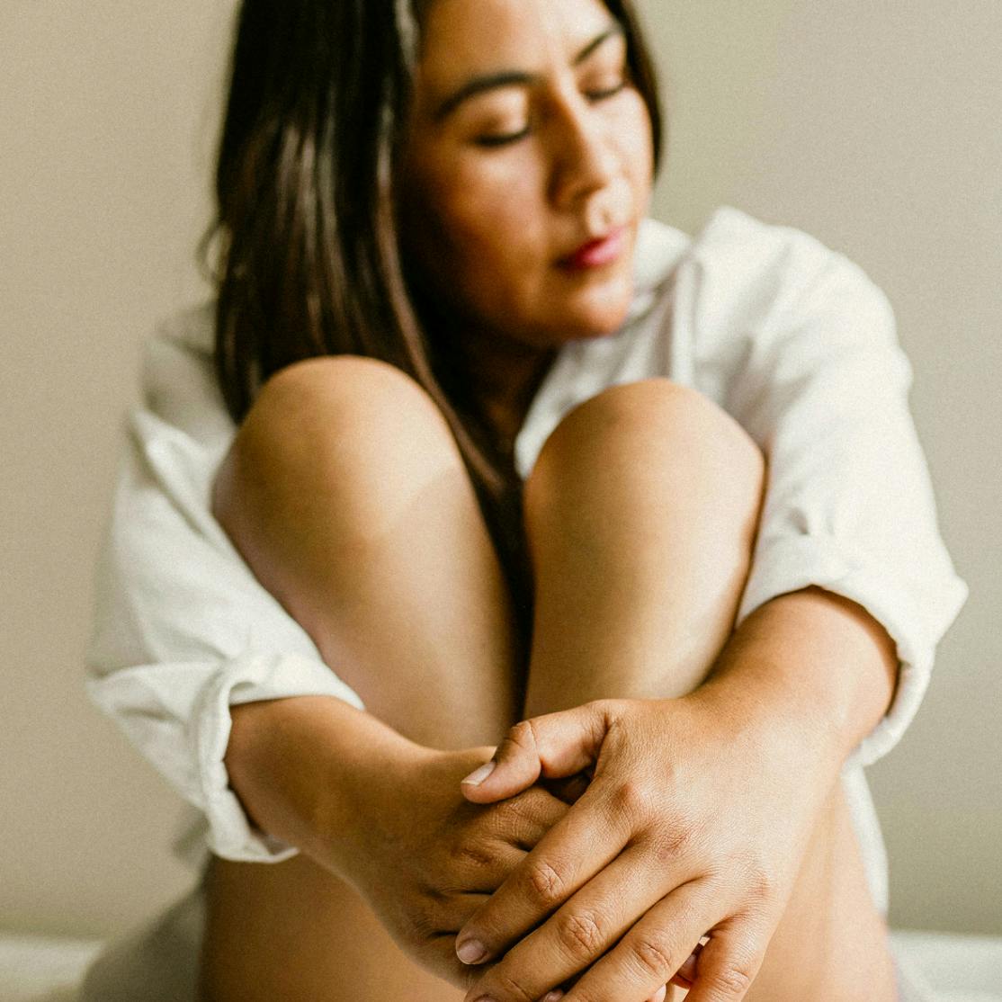 A woman sitting with her legs pulled in