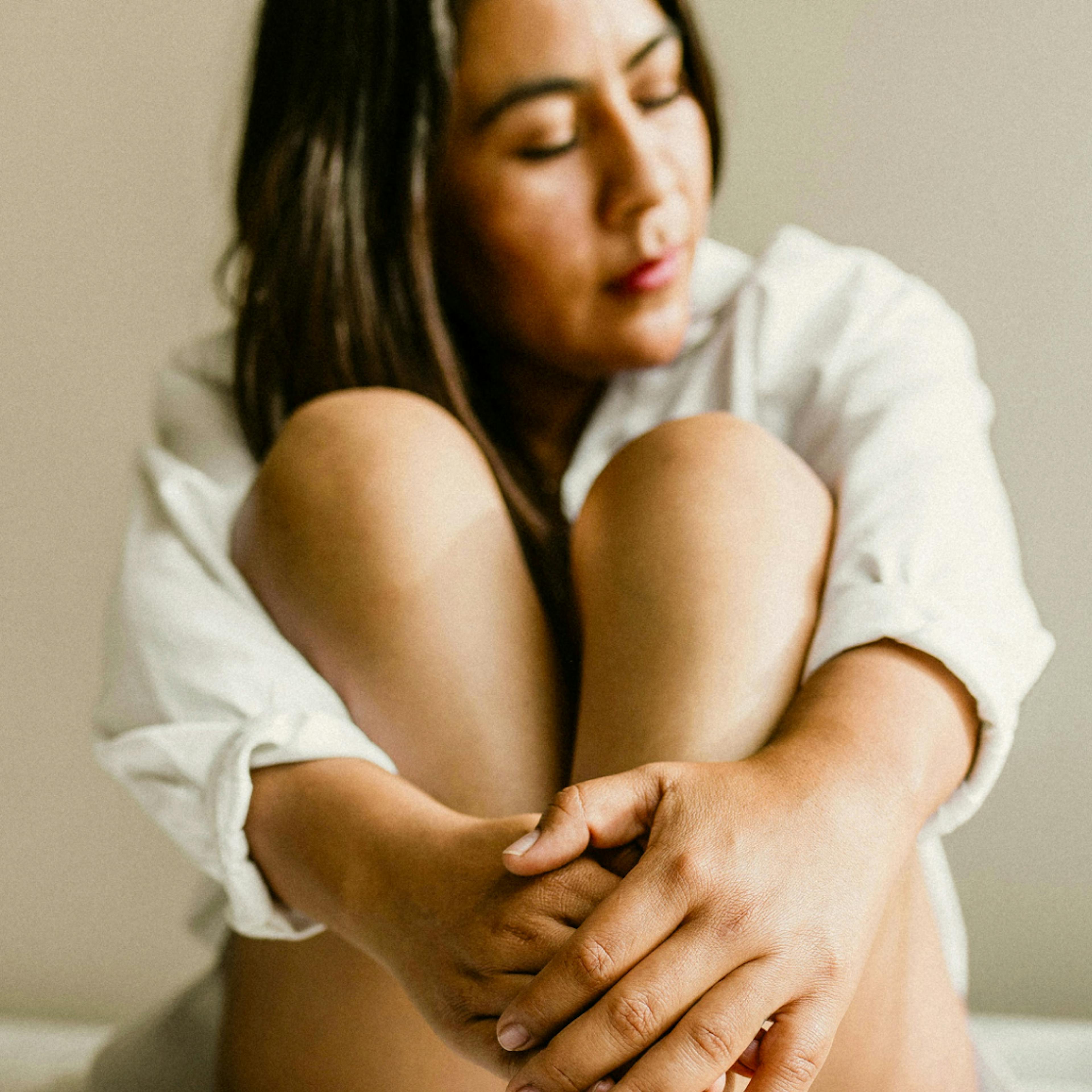 A woman sitting with her legs pulled in