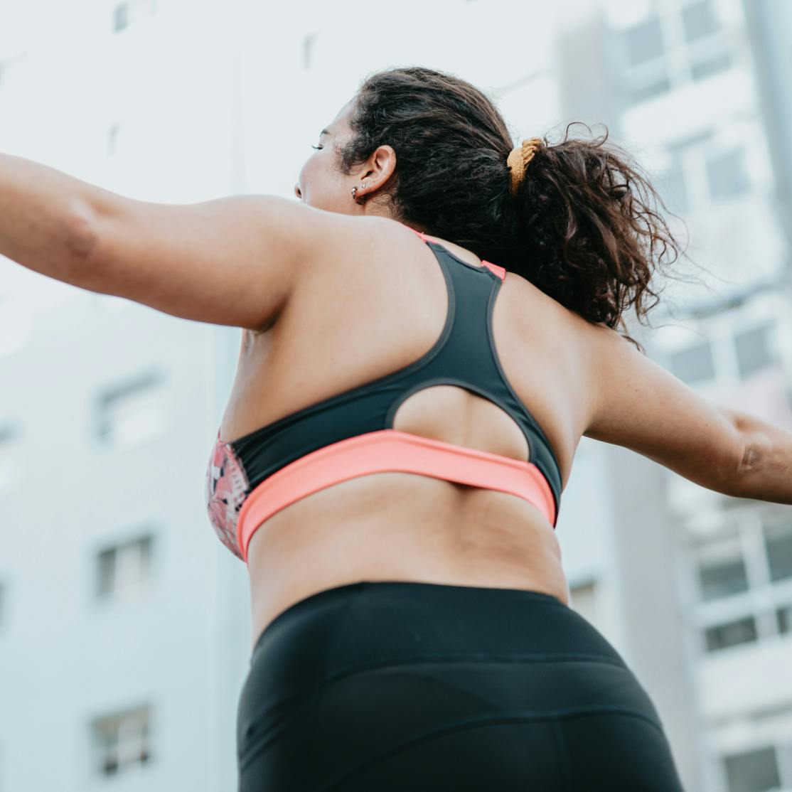 woman wearing a sports bra with arms outstretched