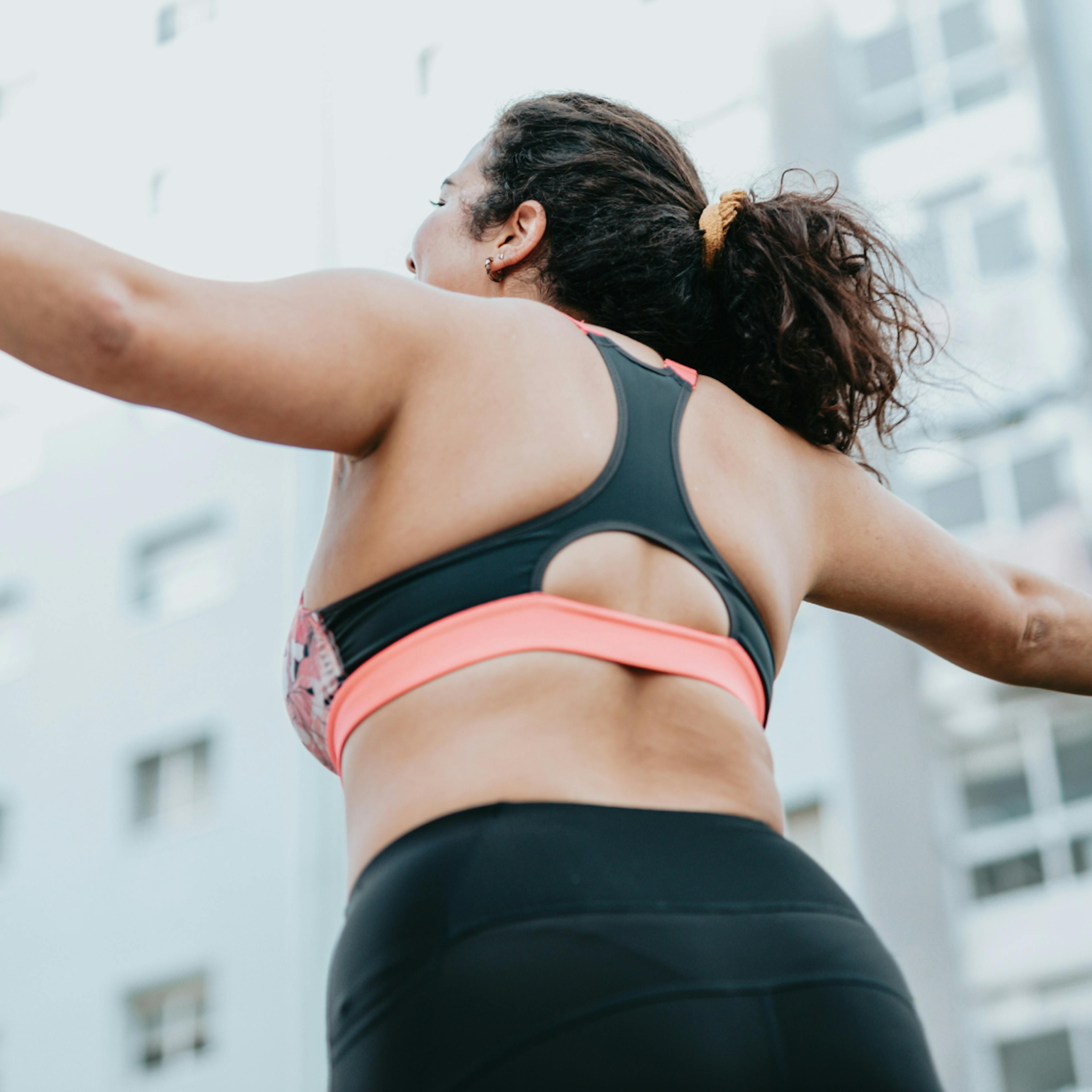 woman wearing a sports bra with arms outstretched