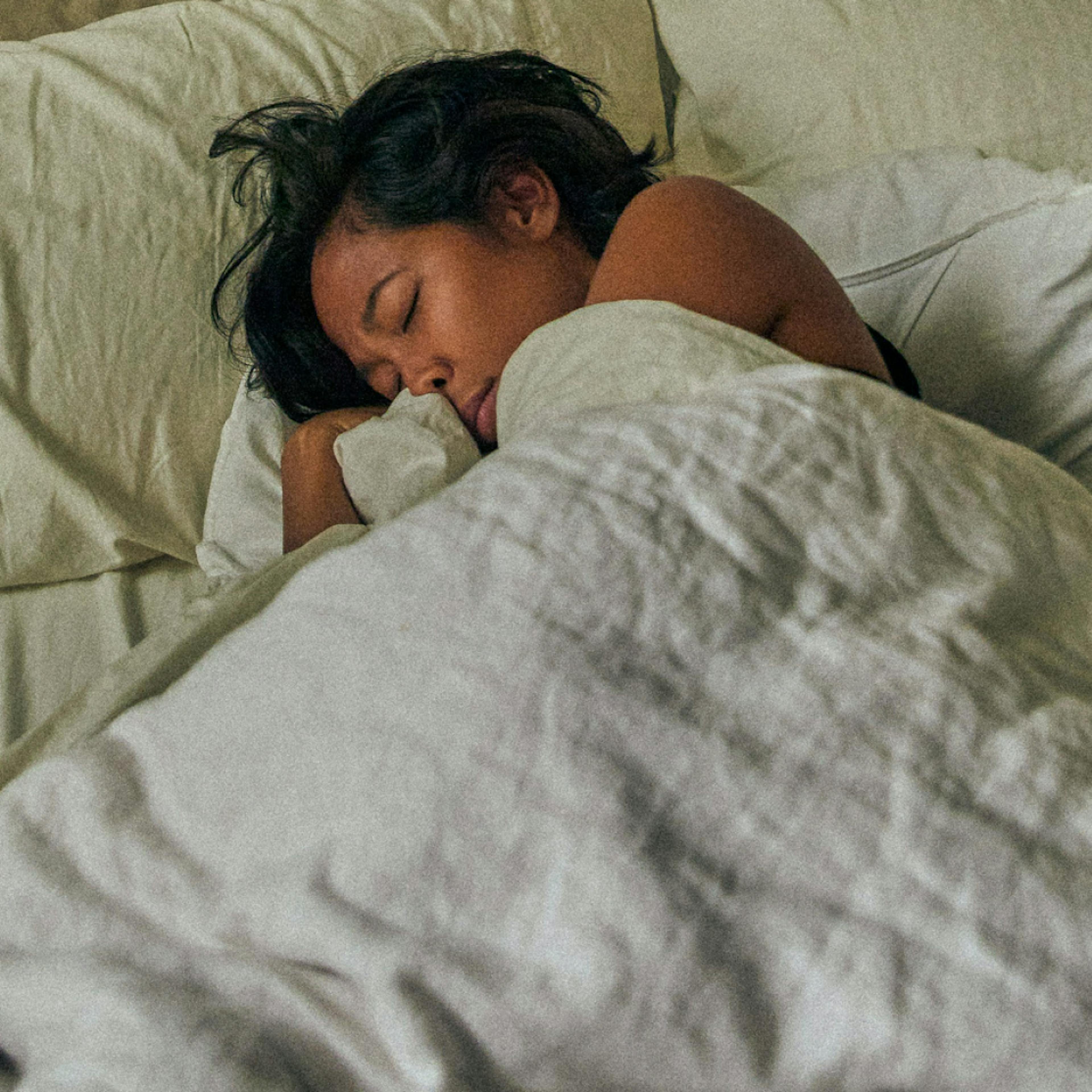 woman curled up in bed sleeping