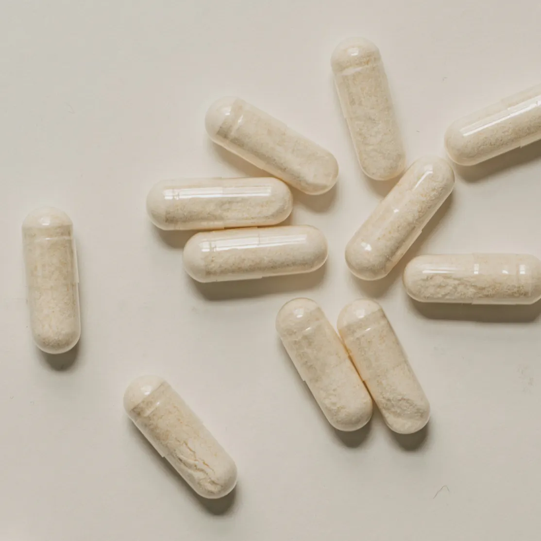 A close-up photo of glycine supplements lying on a white surface.