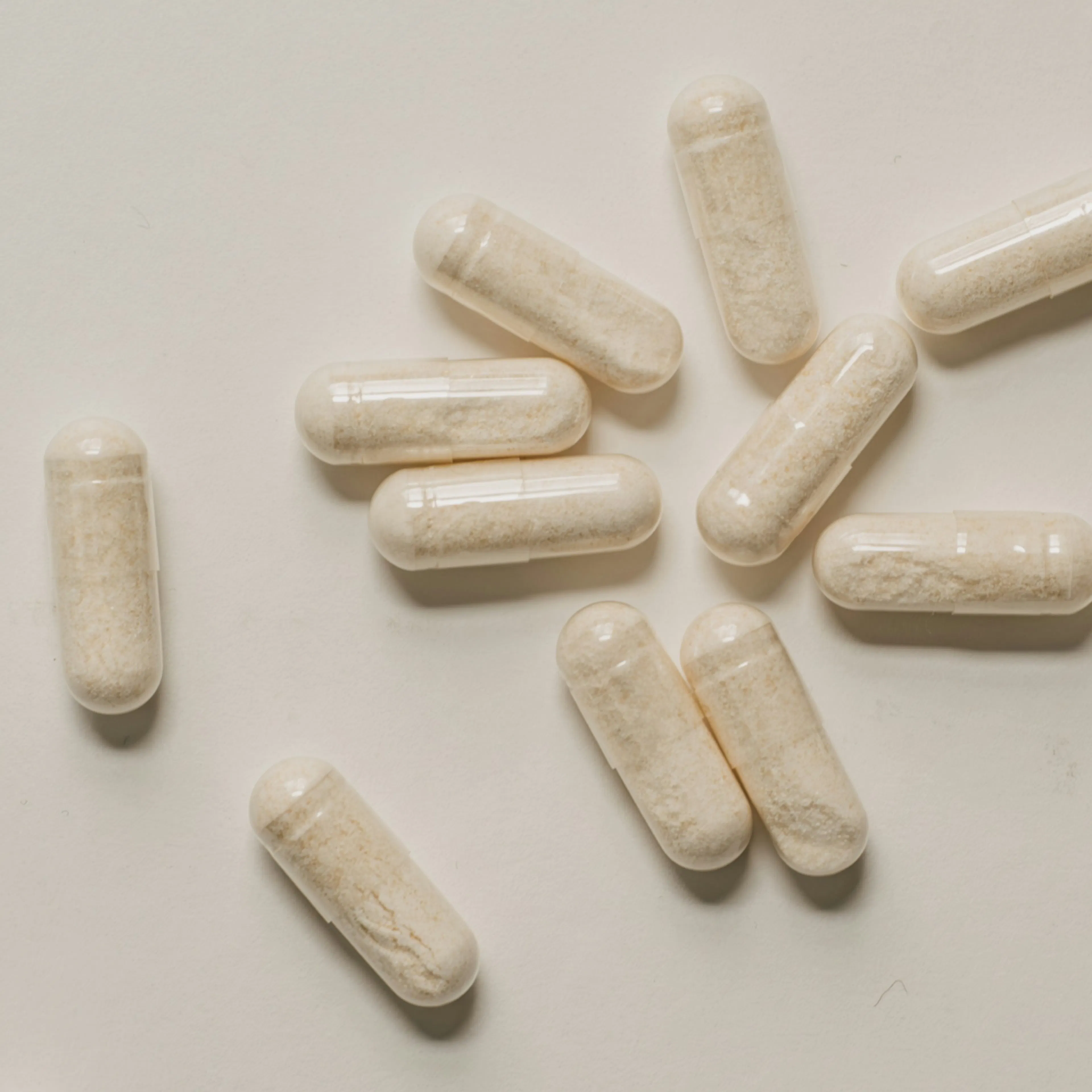 A close-up photo of glycine supplements lying on a white surface.