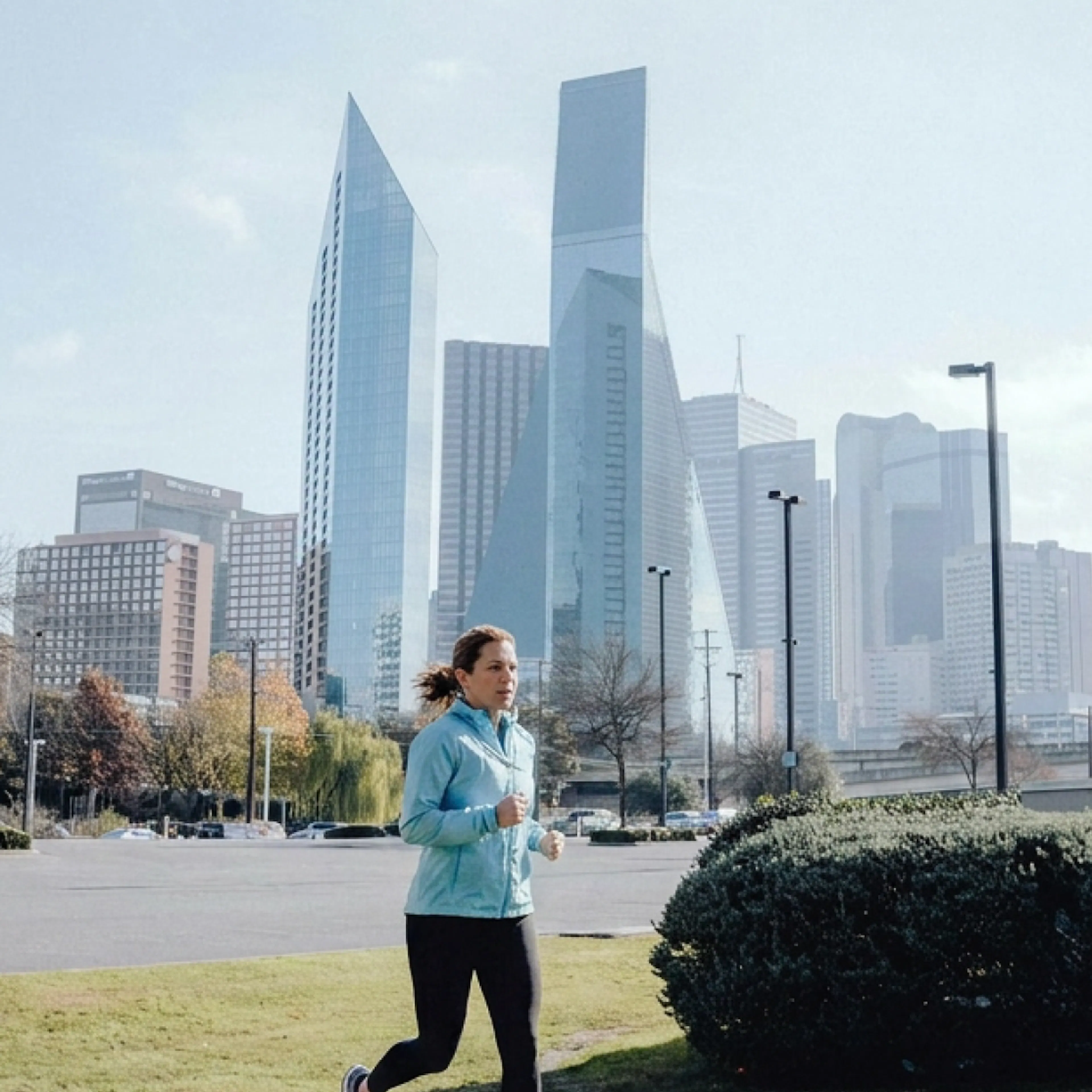 A woman in menopause running with the Dallas skyline in the background.