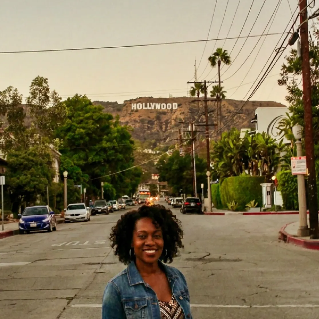 A woman in menopause standing in LA with the Hollywood sign in the background.