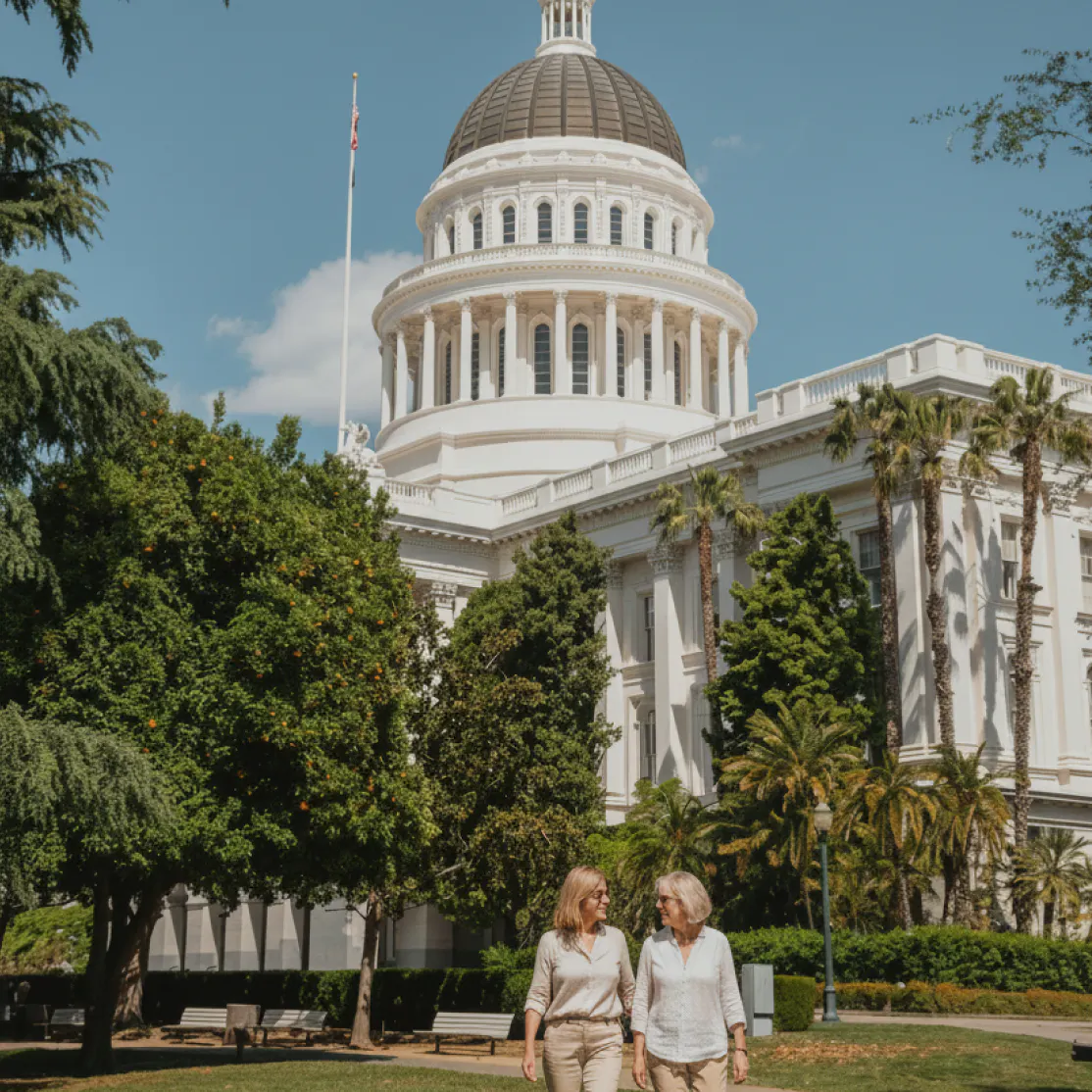 Two women in front of the California State Capitol building in Sacramento, CA.
