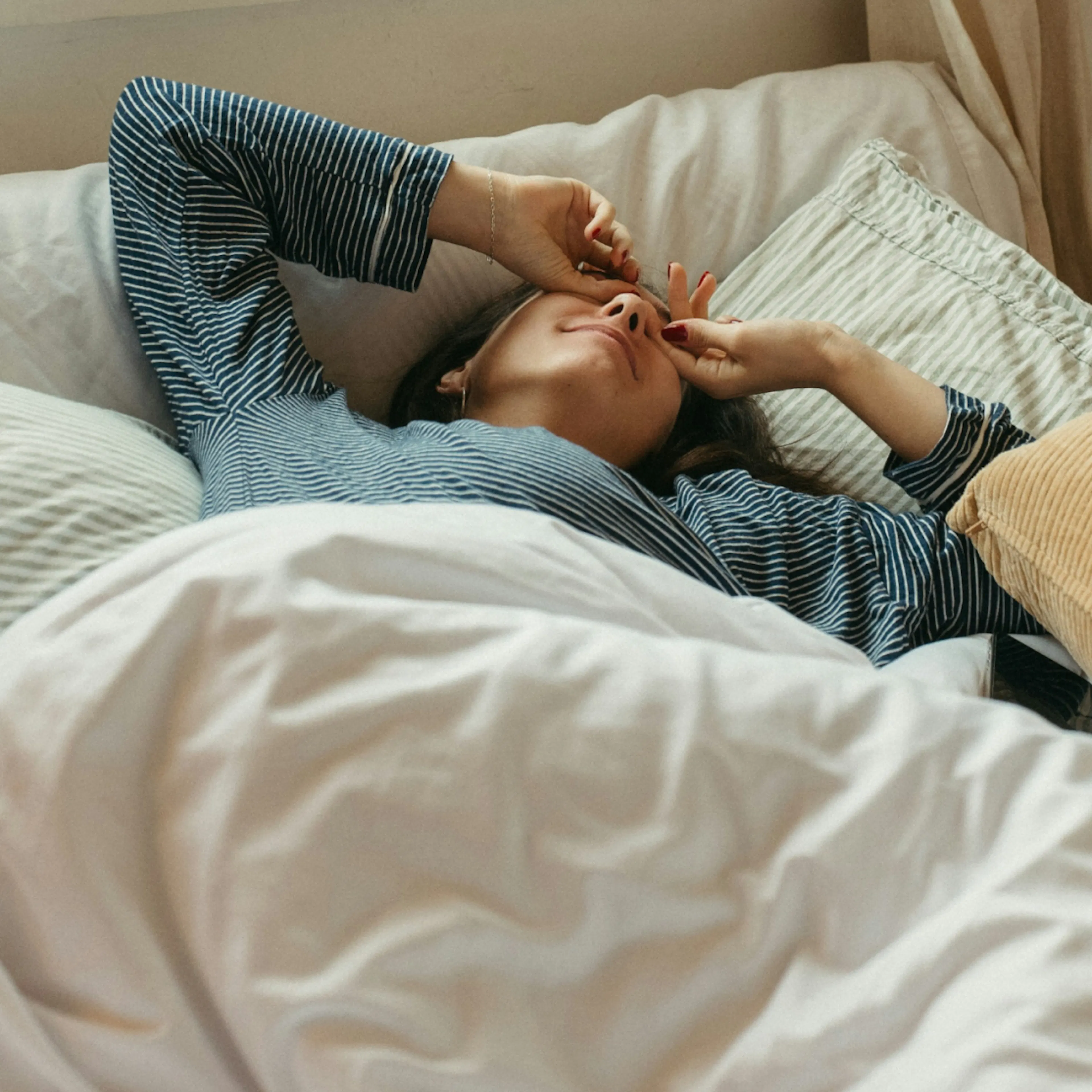 A woman waking up from a night of good sleep.