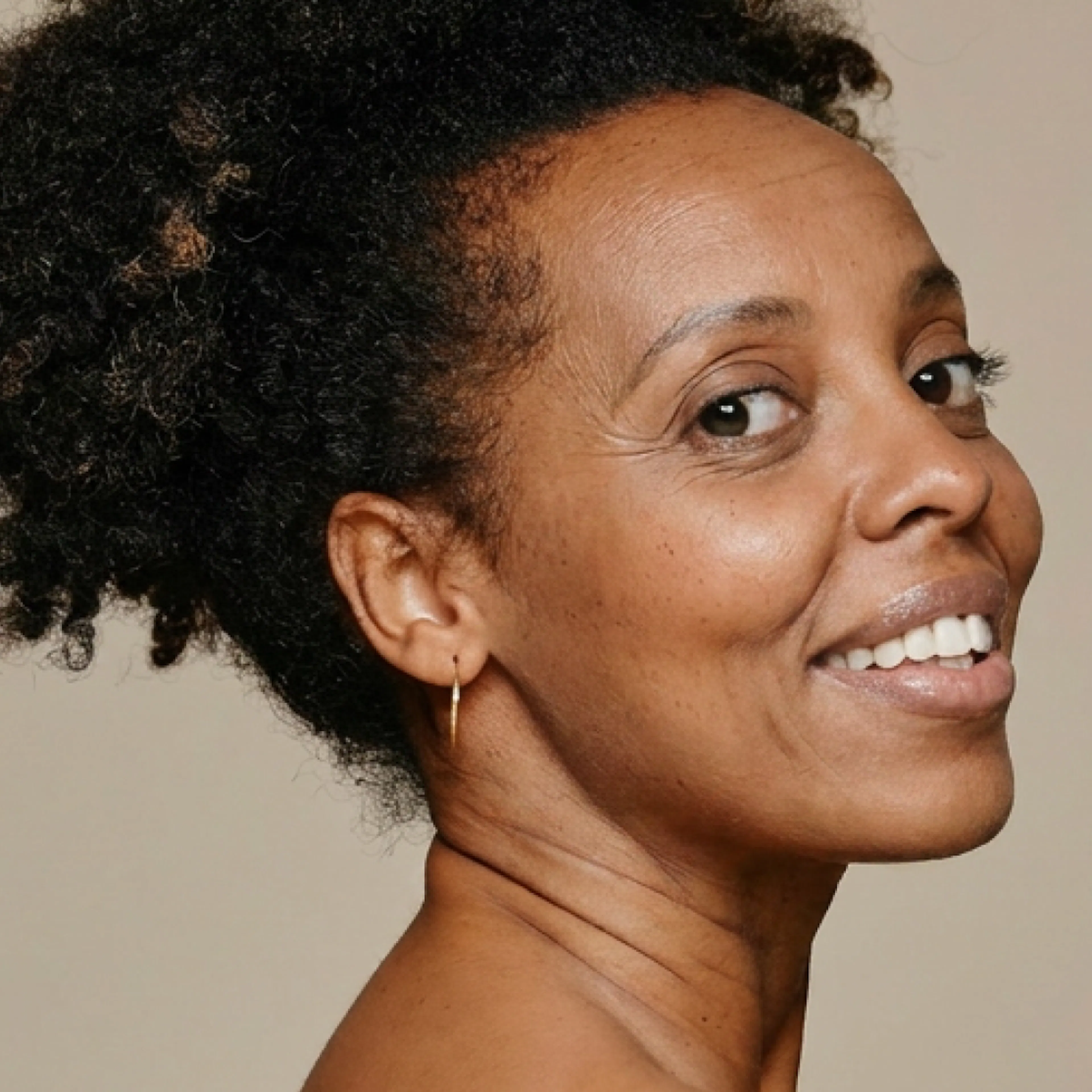 A woman in menopause smiling and looking at the camera.