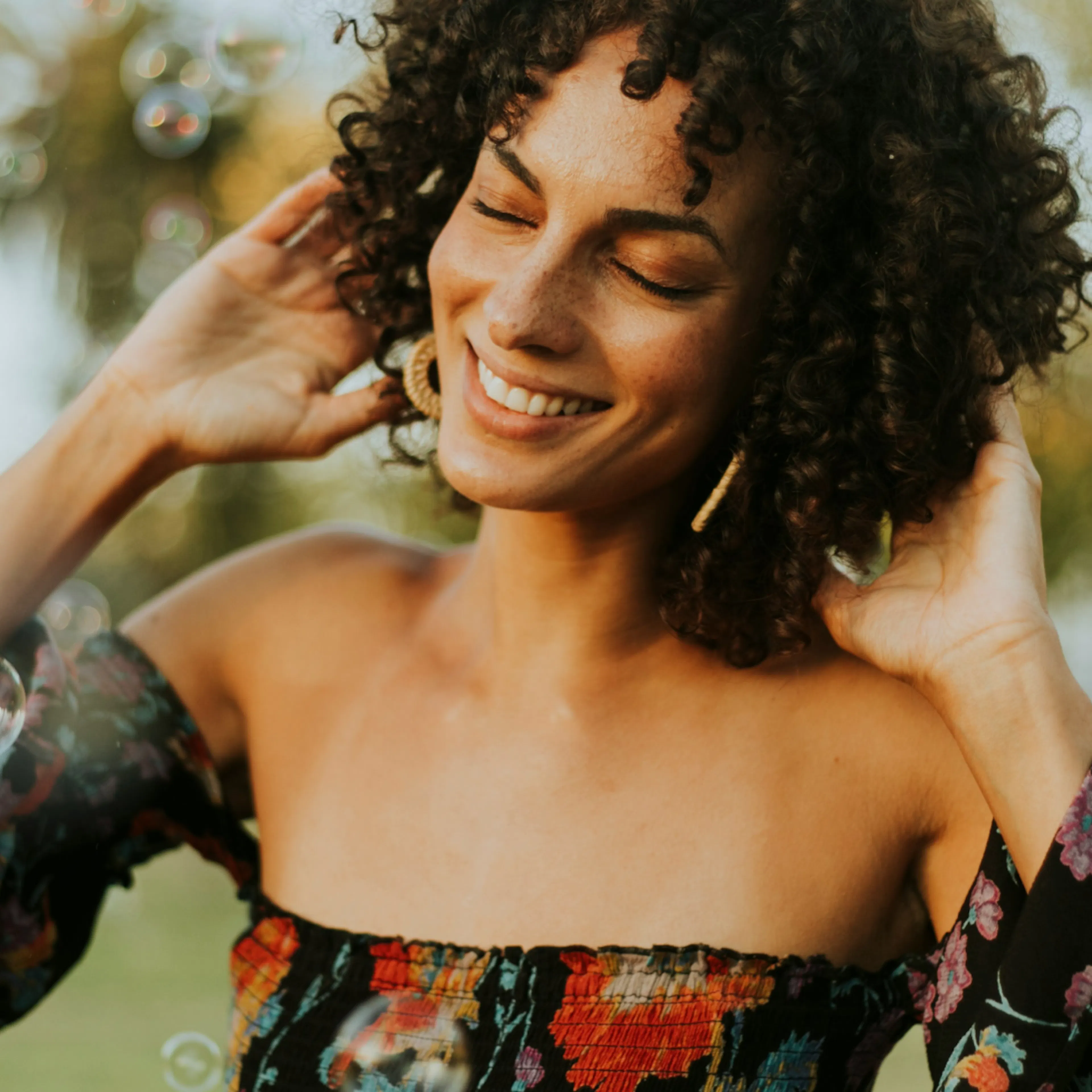 A happy woman in perimenopause smiling with her eyes closed.