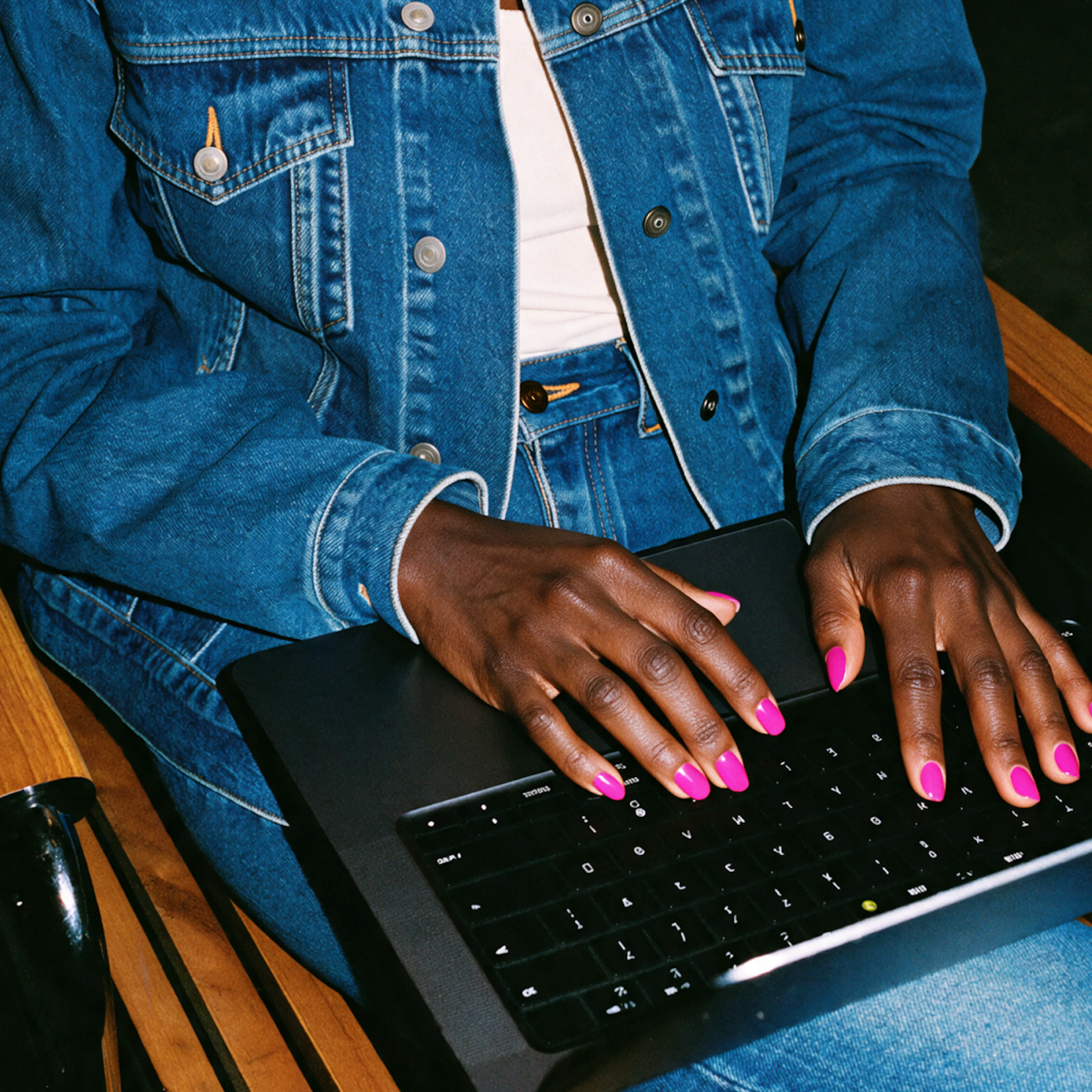 A close-up photo of a woman in midlife researching PCOS or perimenopause on her laptop.