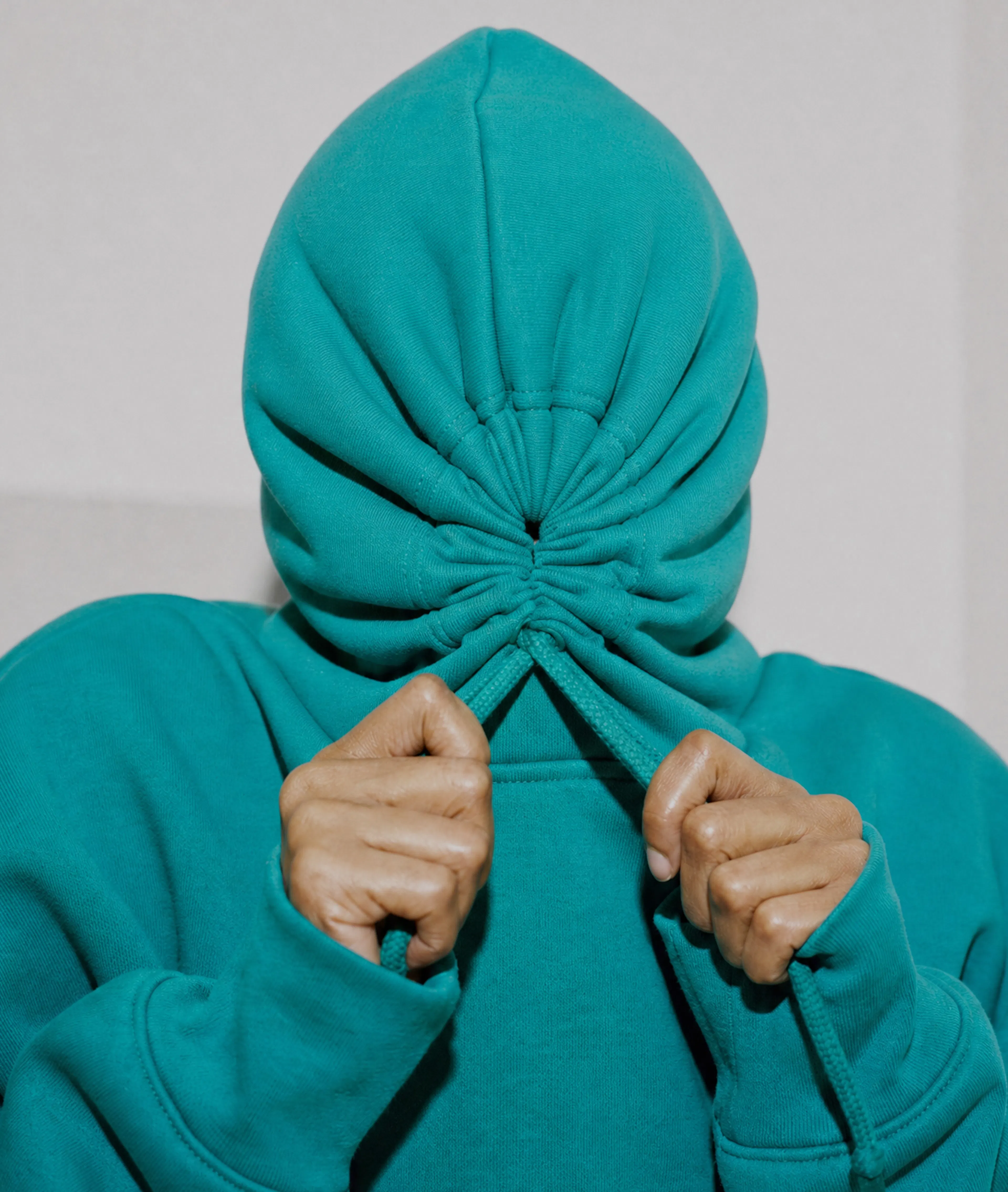 Frustrated person pulling their hoodie over their face after experiencing brain fog.