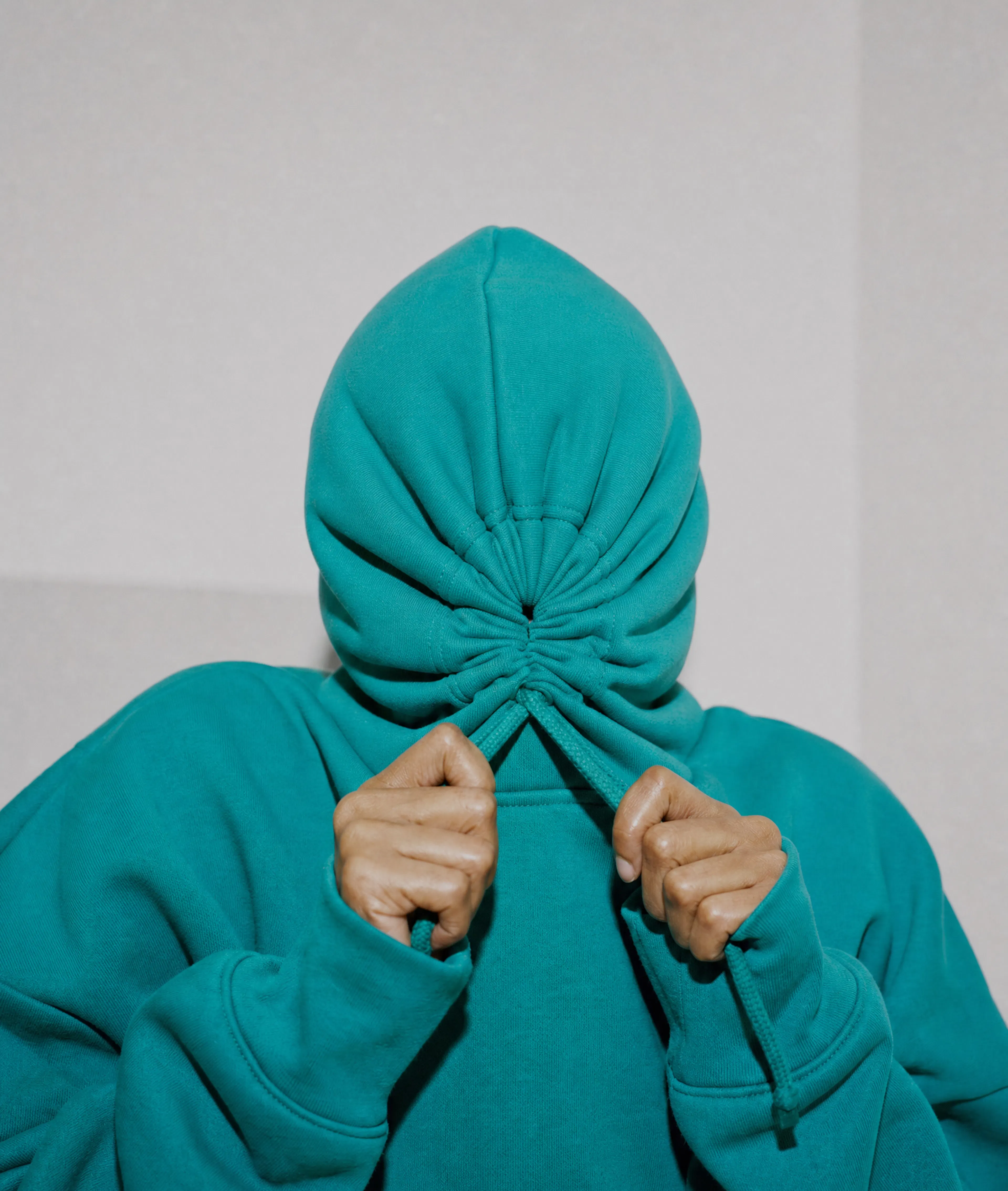 Frustrated person pulling their hoodie over their face after experiencing brain fog
