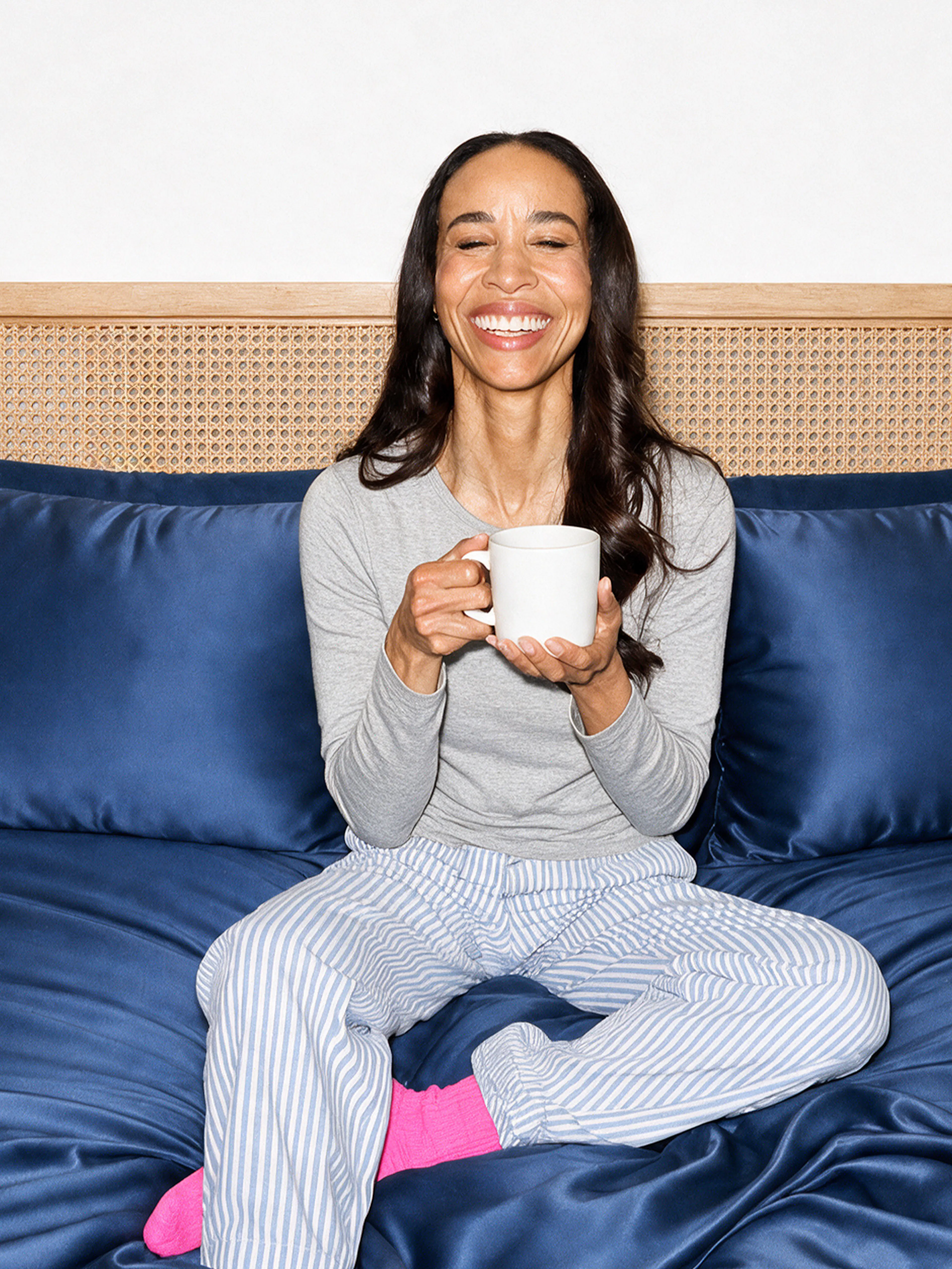 Woman in bed holding coffee mug