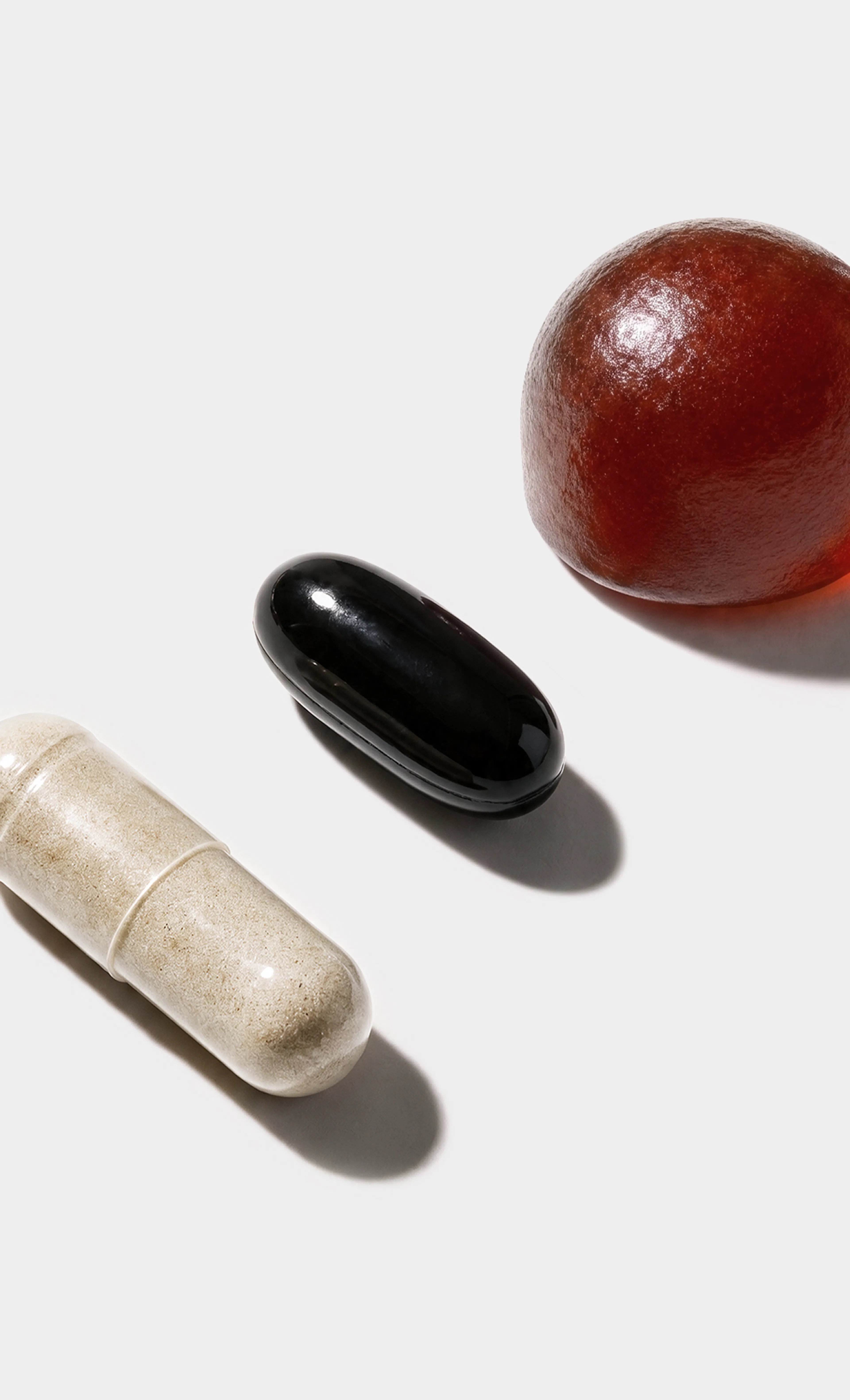 Three different supplement capsules and gummy