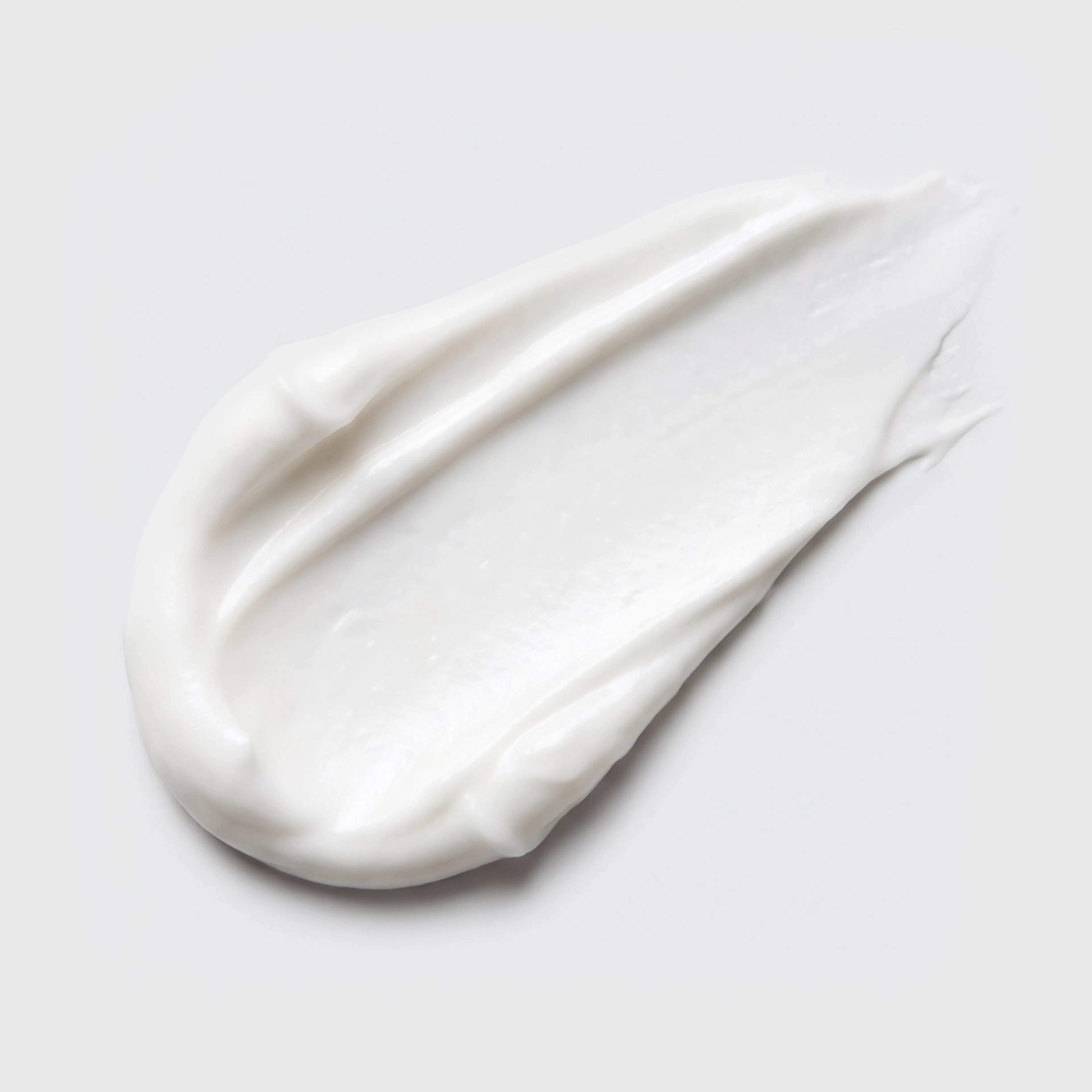 A close-up image of white tretinoin cream smeared on a white background.