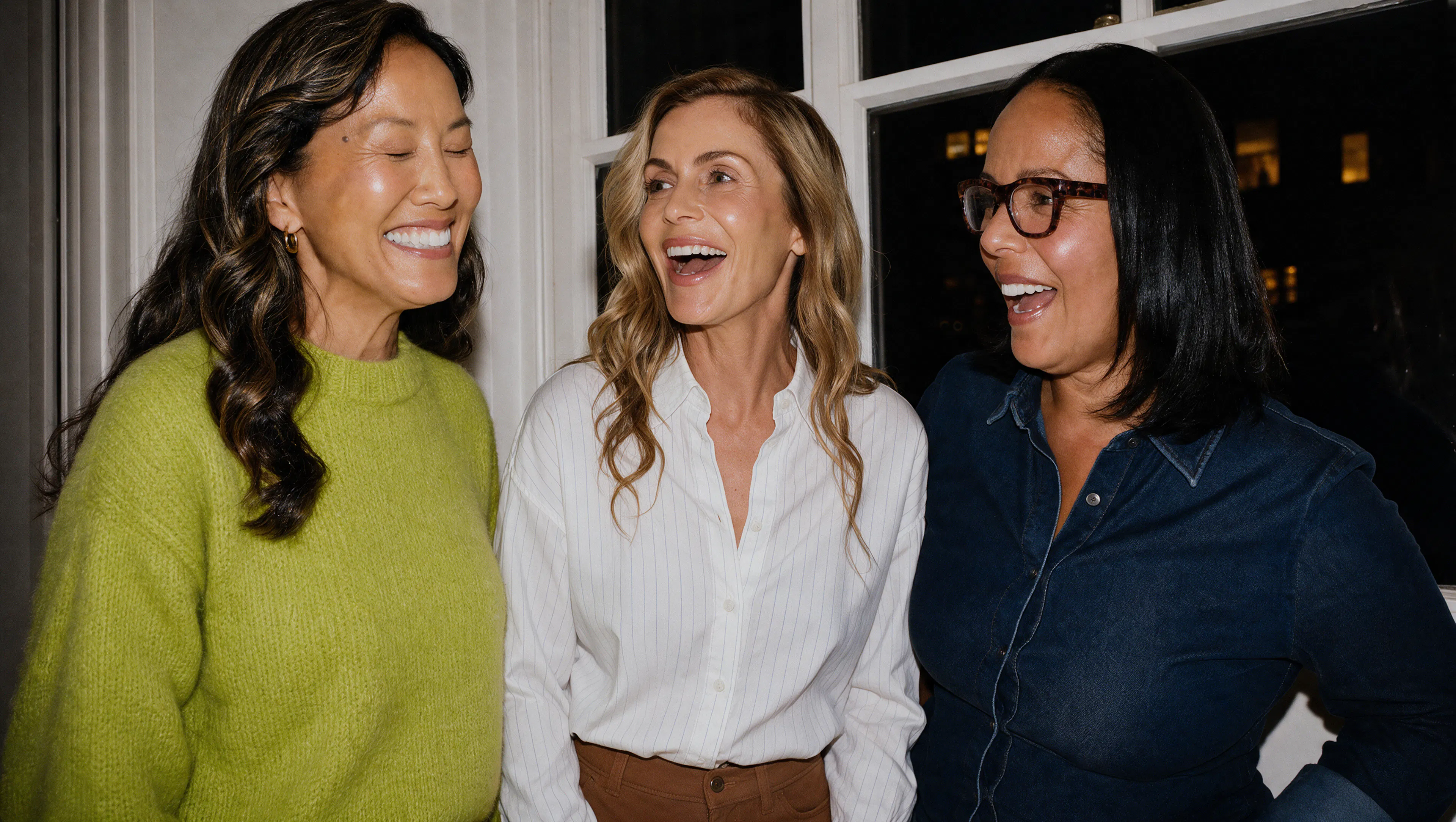 Three diverse women laugh together