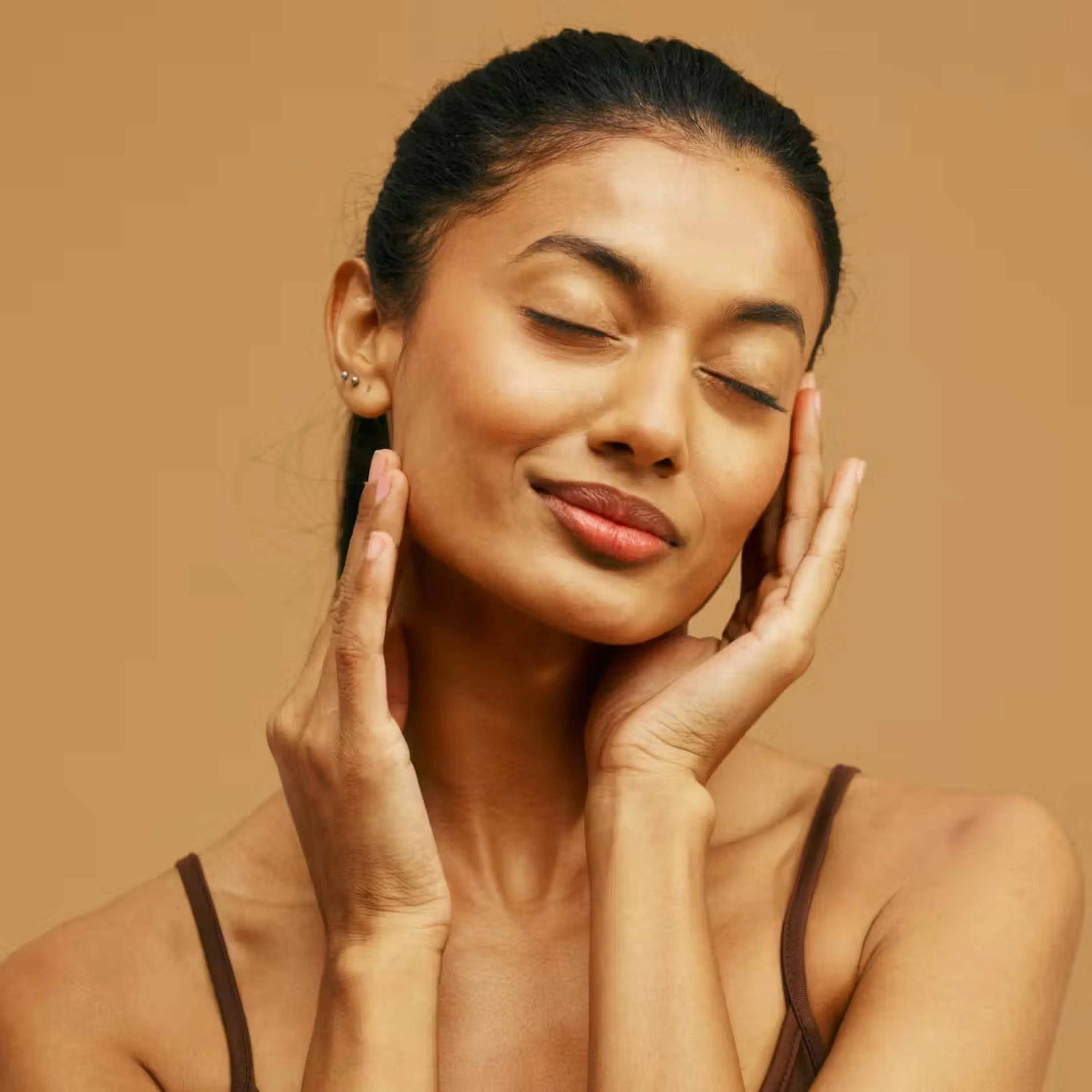 Woman with closed eyes gently holding both hands to face