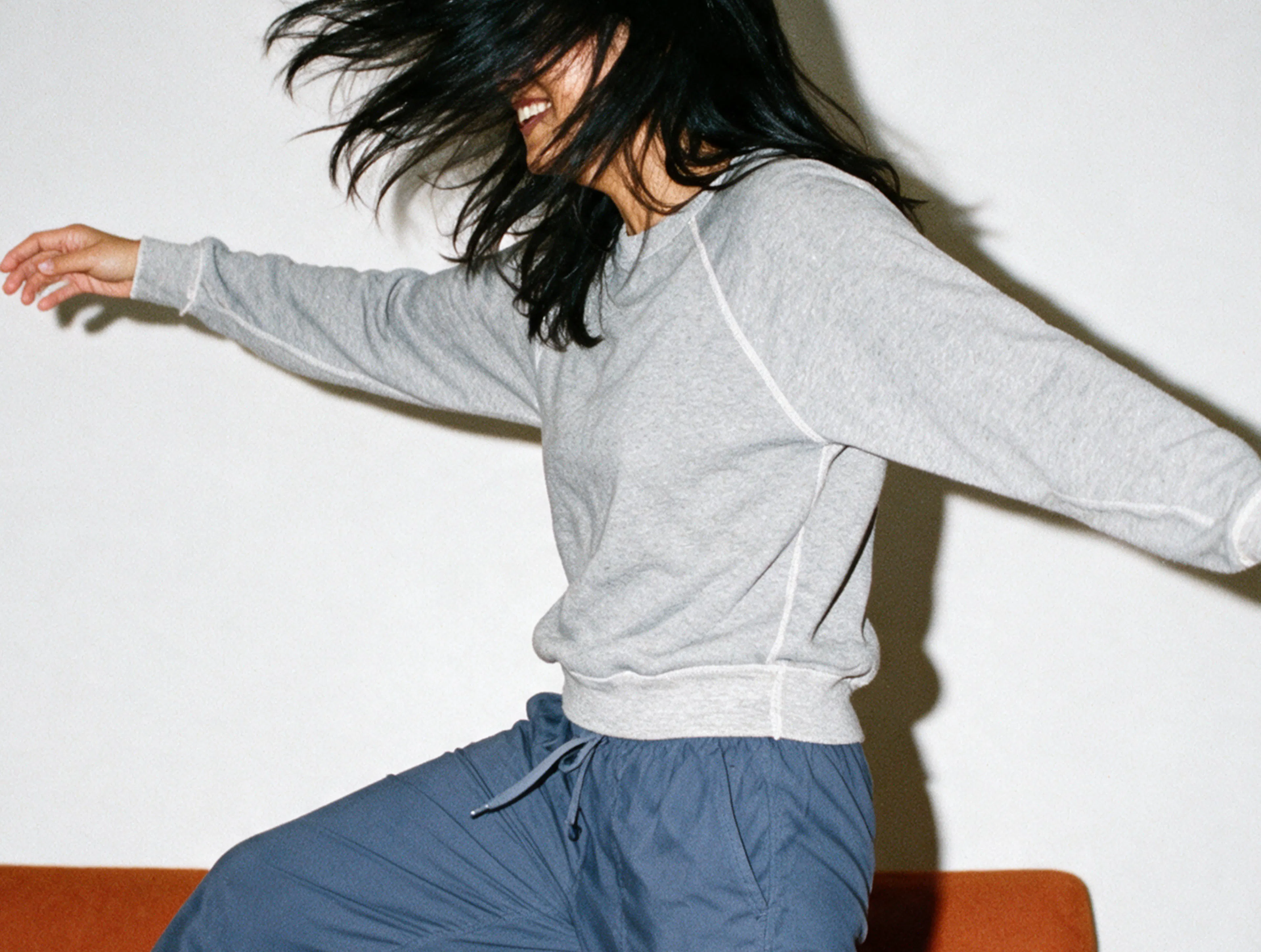 dancing, dance, grey sweater, blue pants, brunette, white background