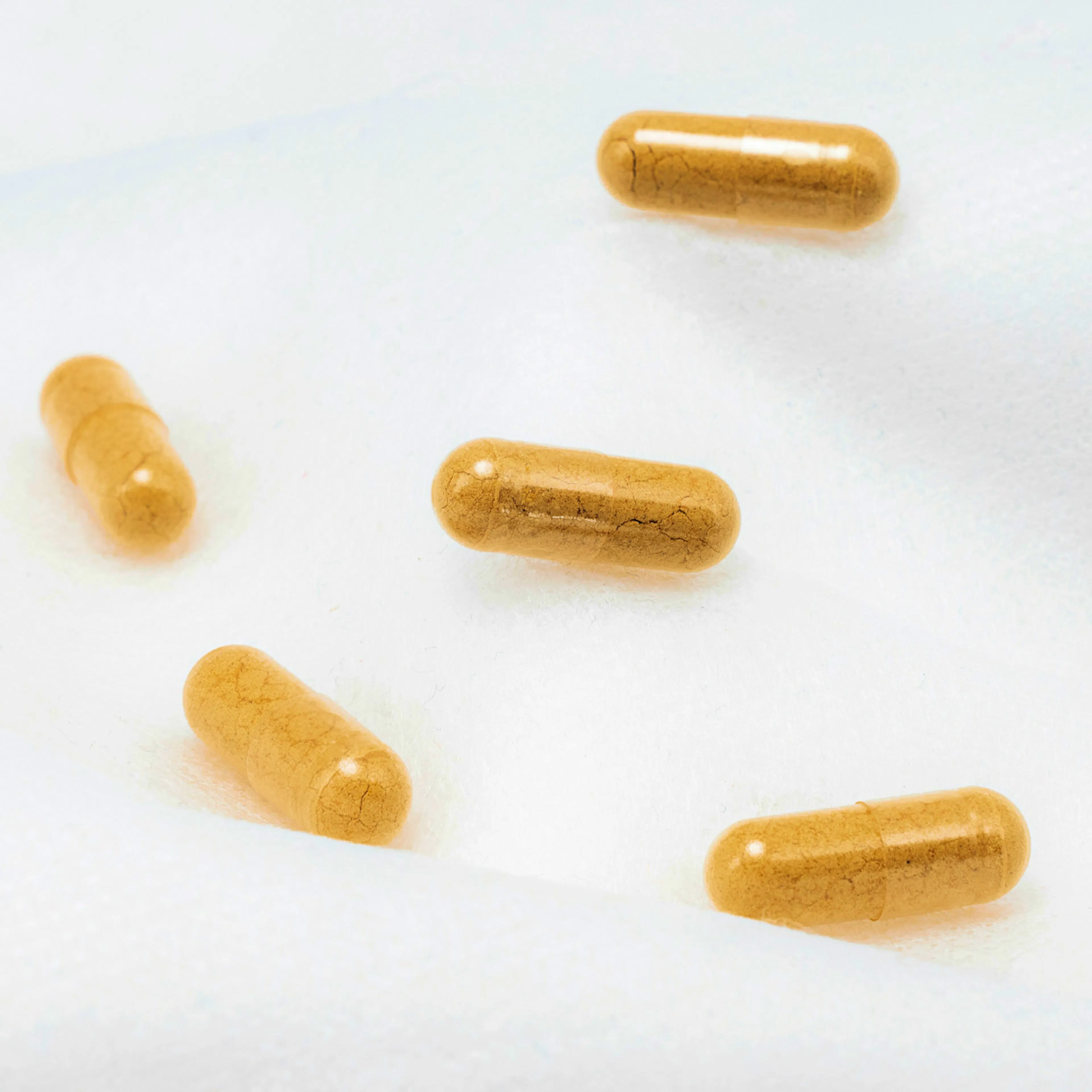 A close-up image of some saffron supplements against a white background.