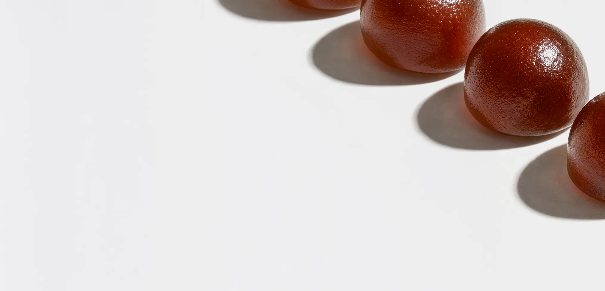 Diagonal row of red gummy supplements.