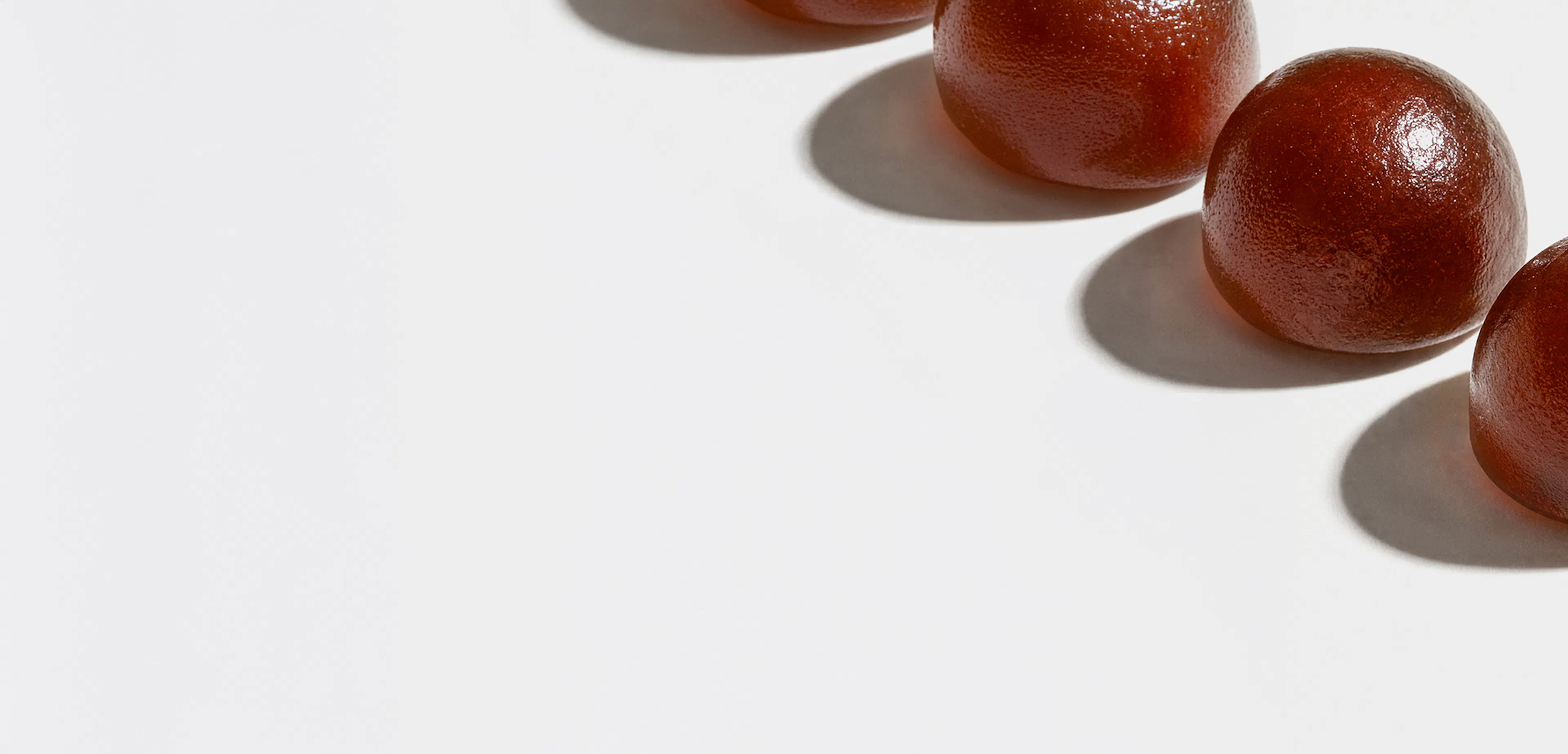 Diagonal row of red gummy supplements. 