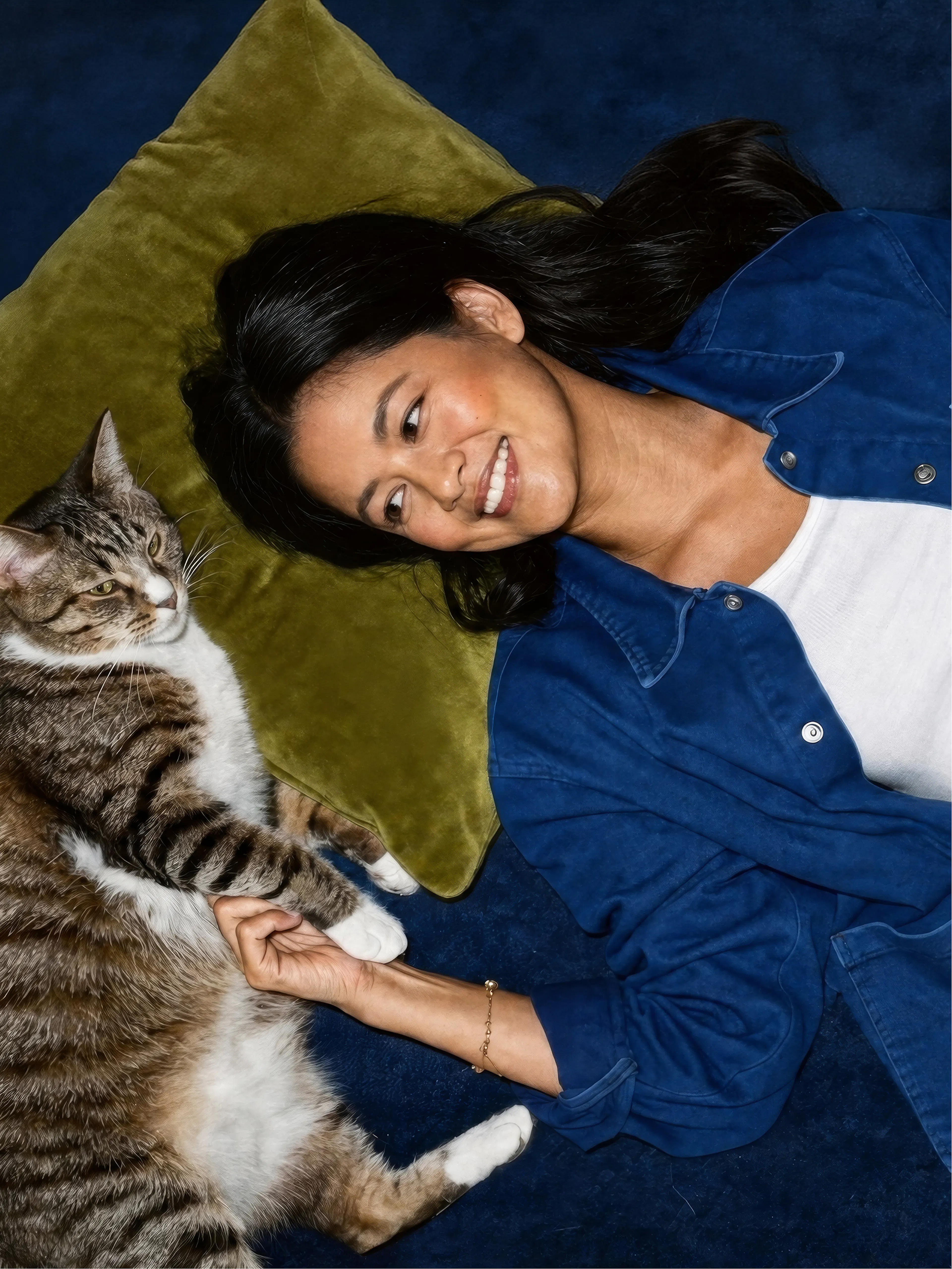 Smiling woman lying beside a cat
