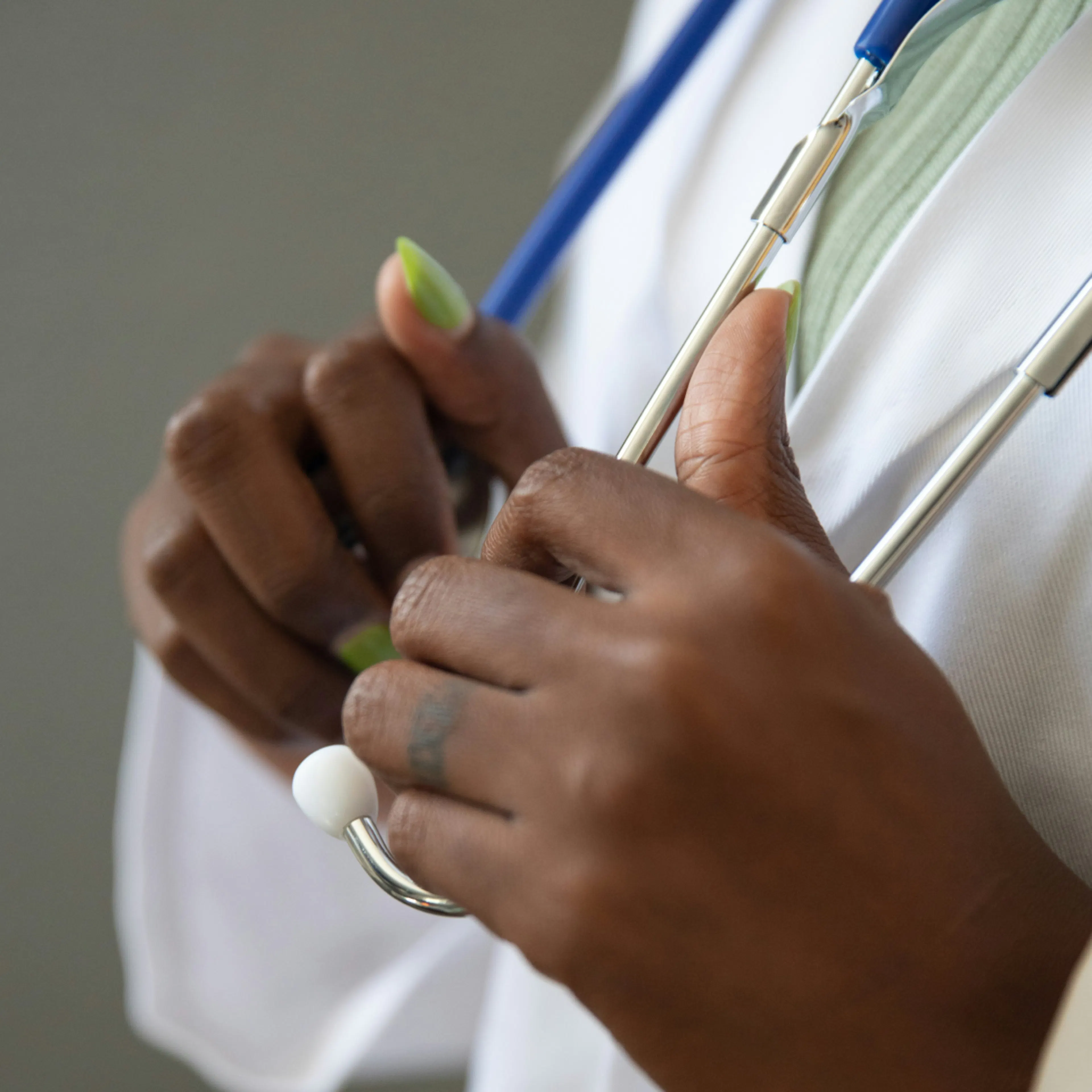 A close-up photo of a clinician's hands on a stethoscope. 