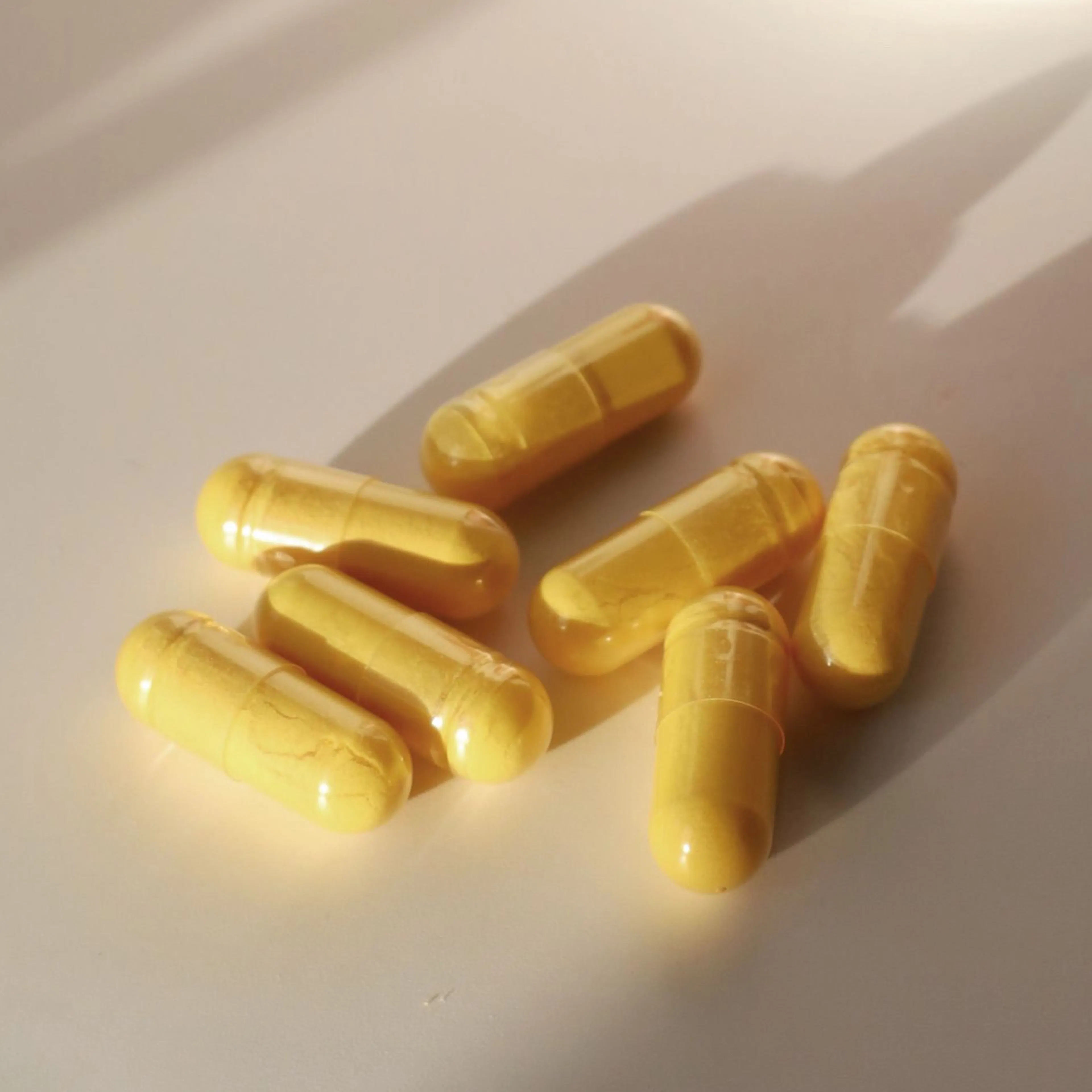 Close-up image of yellow supplements sitting on the counter.