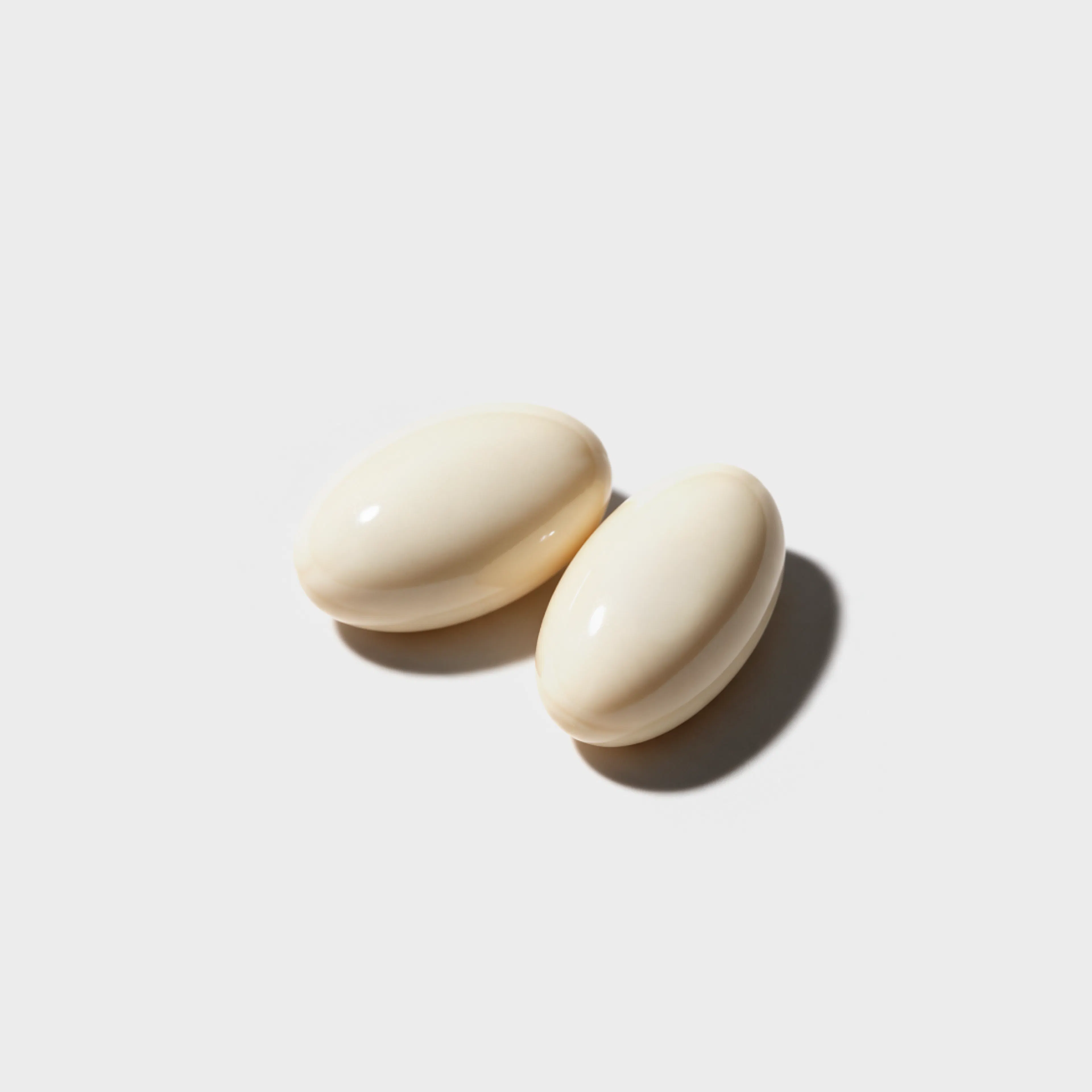 A close-up photo of two vaginal estrogen tablets on a white surface.
