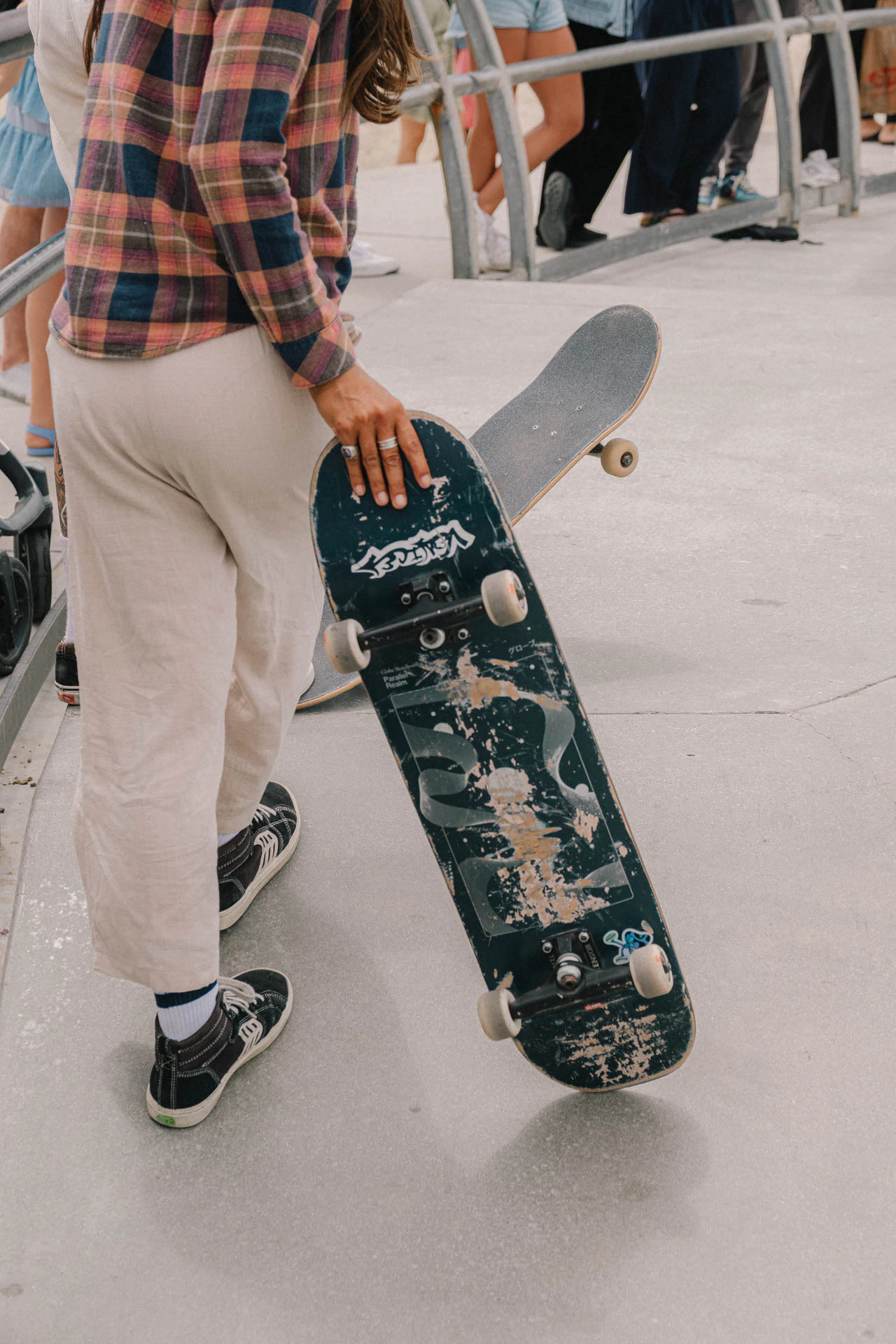 Venice Beach skateboarder holding her skateboard waiting to drop in