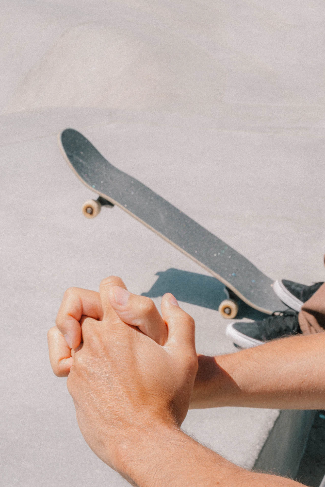 Hands together next to a skateboard in Venice Beach