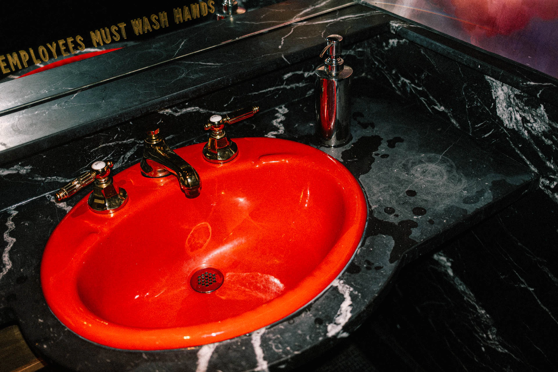 Bright red sink in a marble bathroom. Red Sink #02 from Jonathan Grado's Hold Down to Flush.