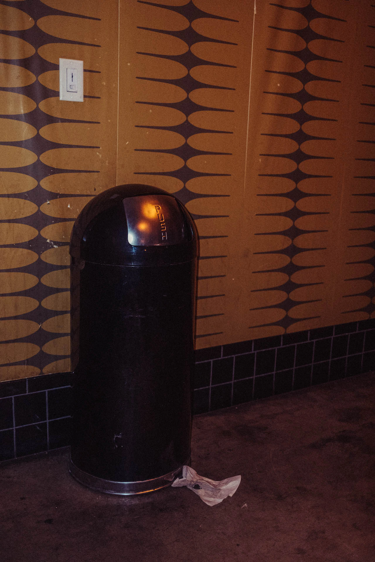 Trashcan in a bathroom. Trash from Jonathan Grado's Hold Down to Flush.