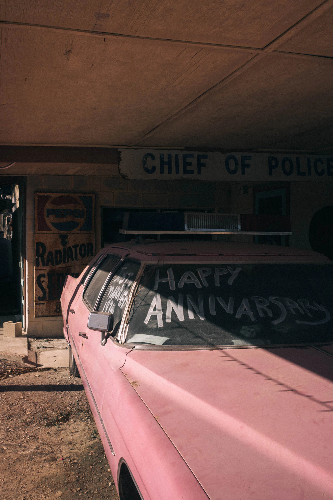 old pink car with happy anniversary written on the windshield