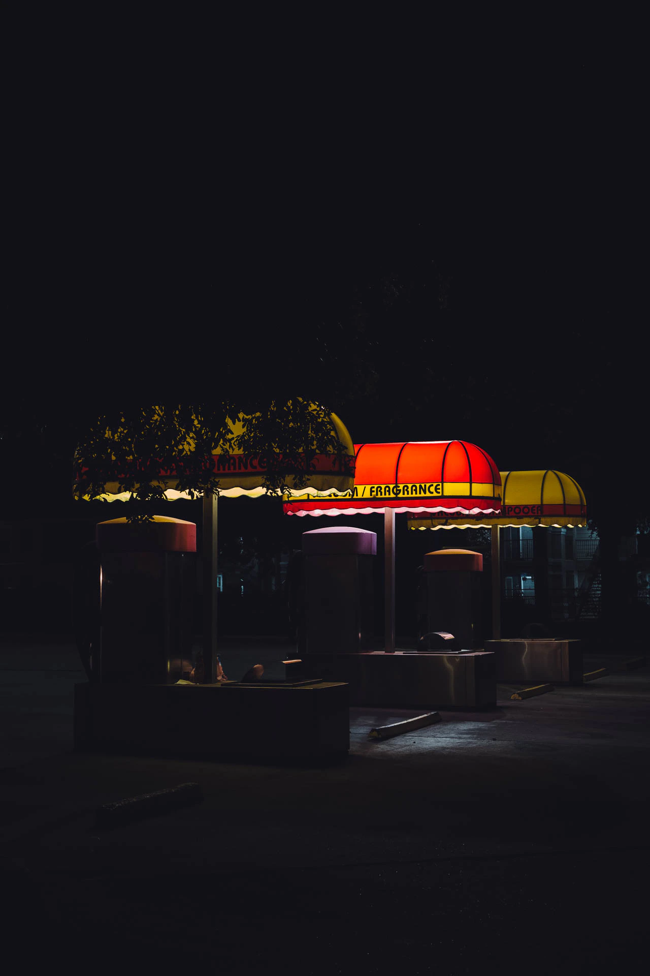 vacuum and fragrance. the yellow and red awnings of a retro car wash at night
