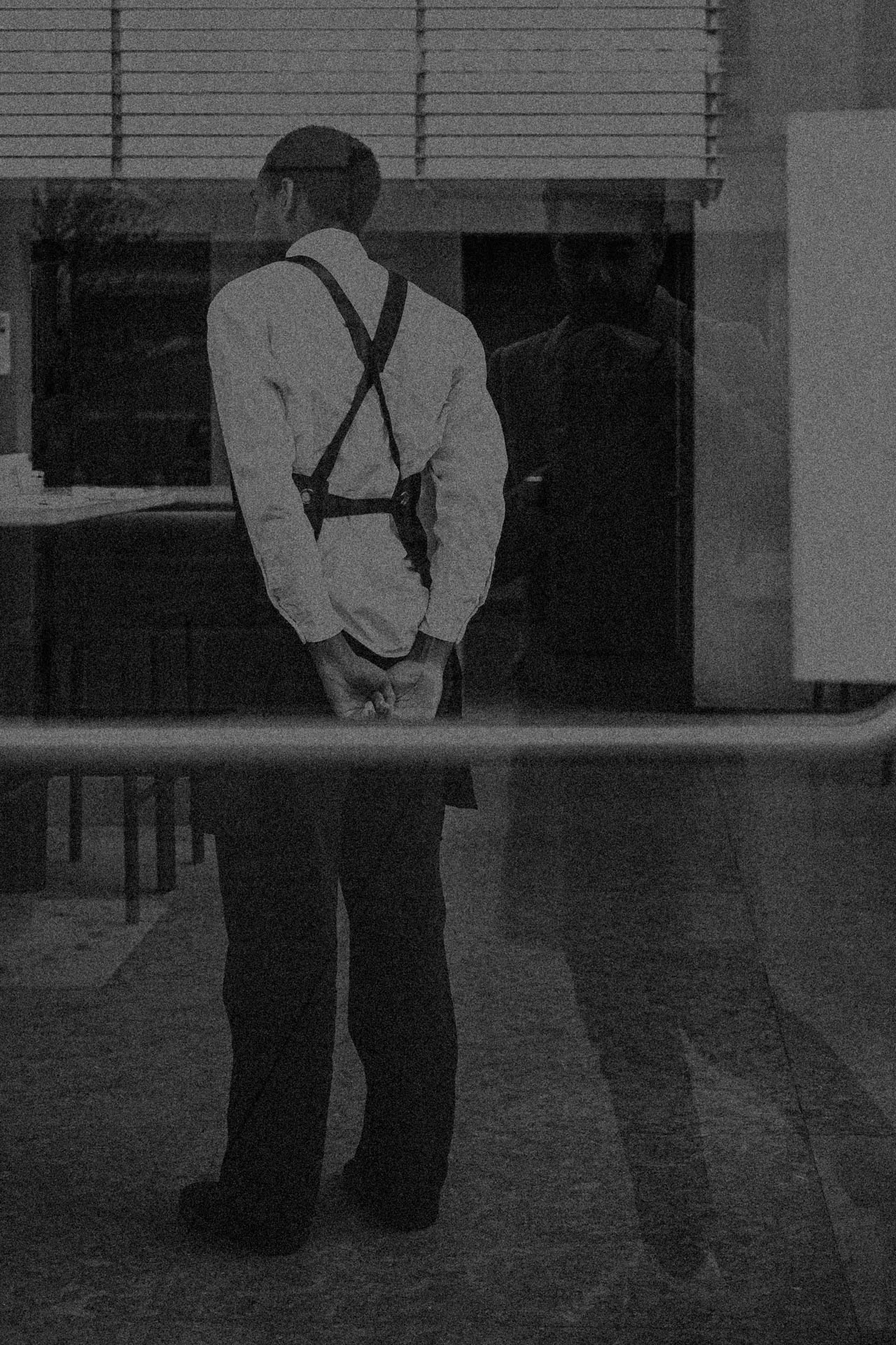 Jonathan Grado in reflection and waiter working. Walking in New York. Grainy