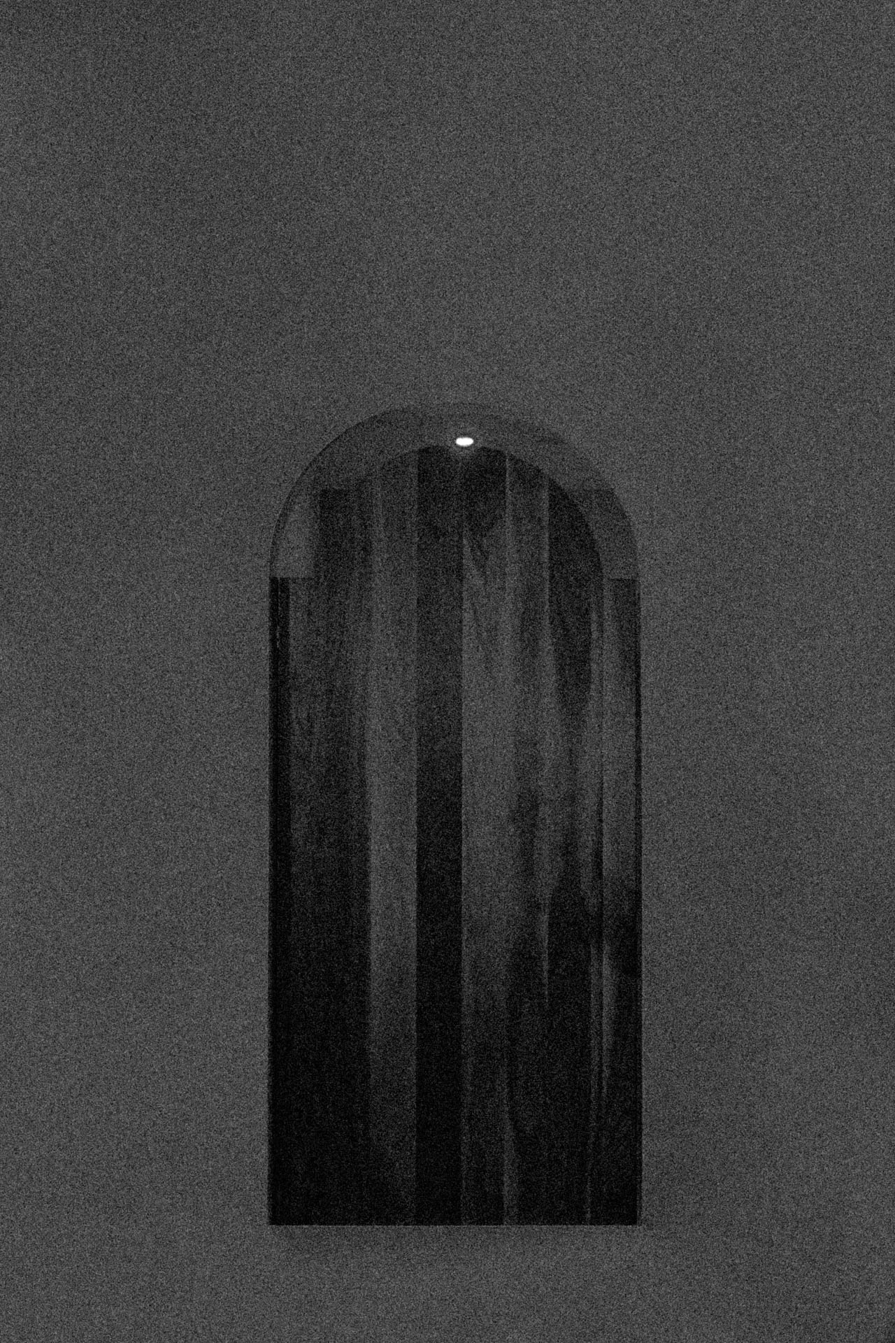 A black and white grainy door floating in the middle of nowhere. A Door at the End from Jonathan Grado's Dirty Static.