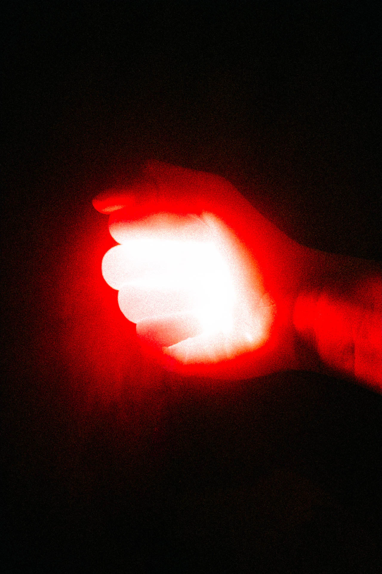 Grainy red hand emitting red light from a fist. We Need to Talk from Jonathan Grado's Dirty Static.