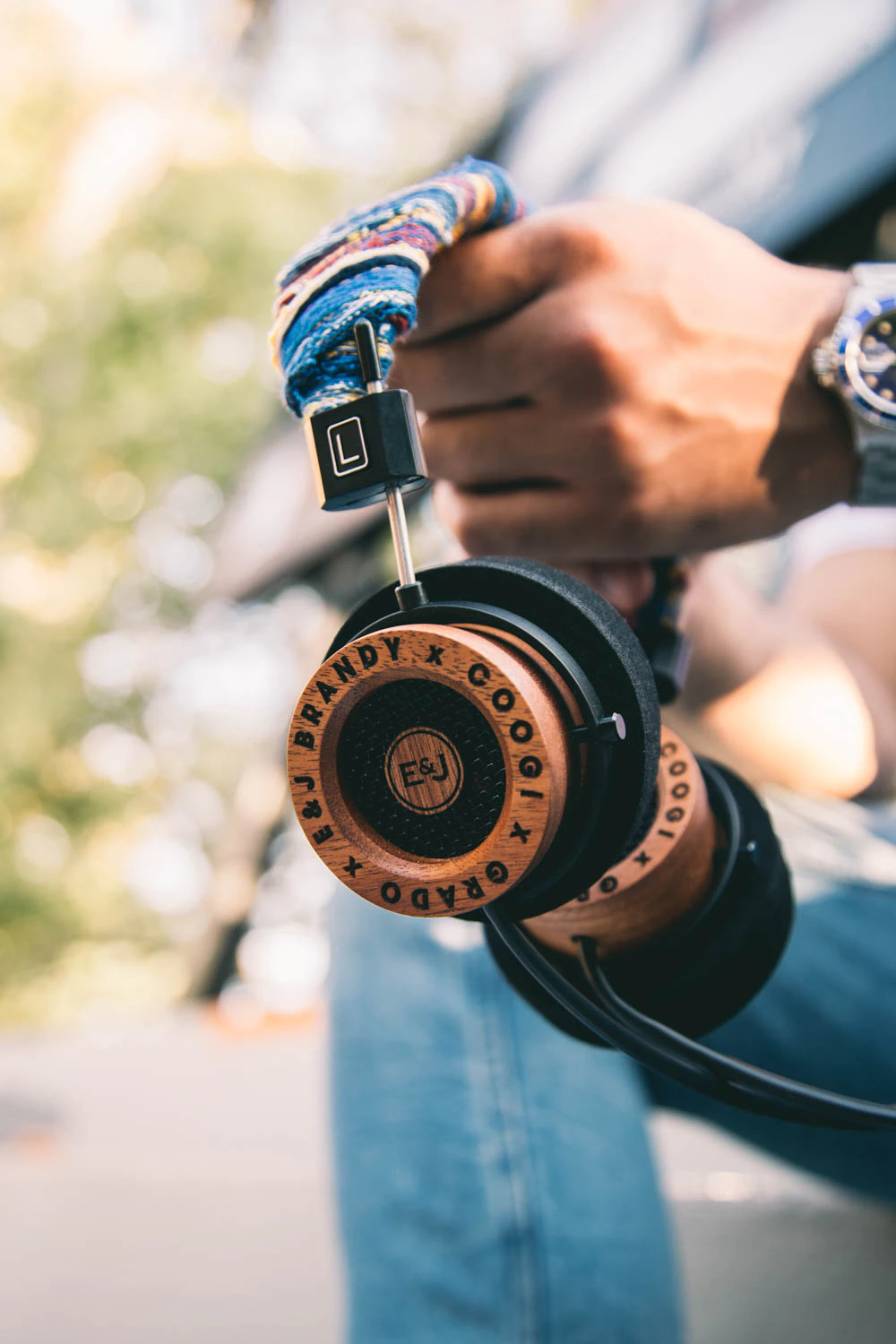 man holding Grado Labs x Coogi x EJ headphones