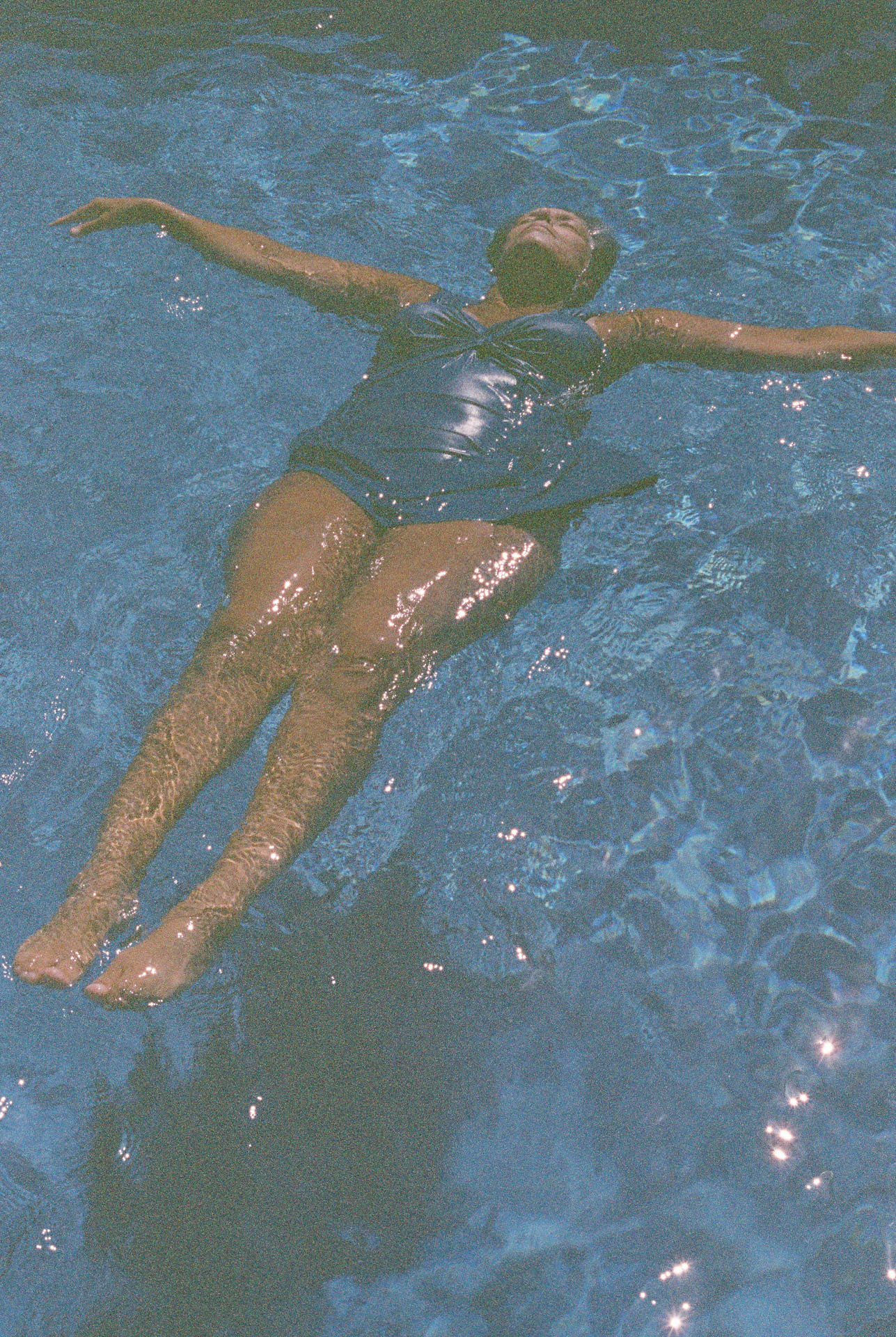 woman floating in pool on film