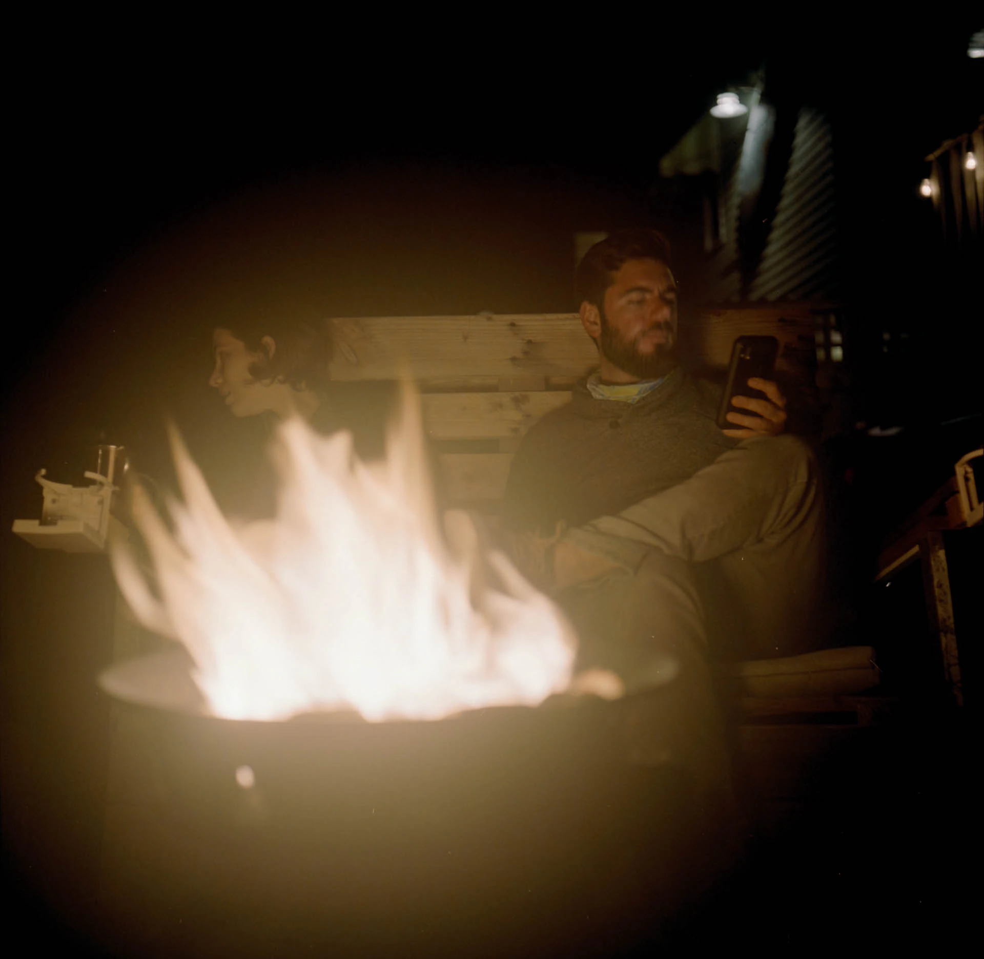 a man and woman by a campfire on film
