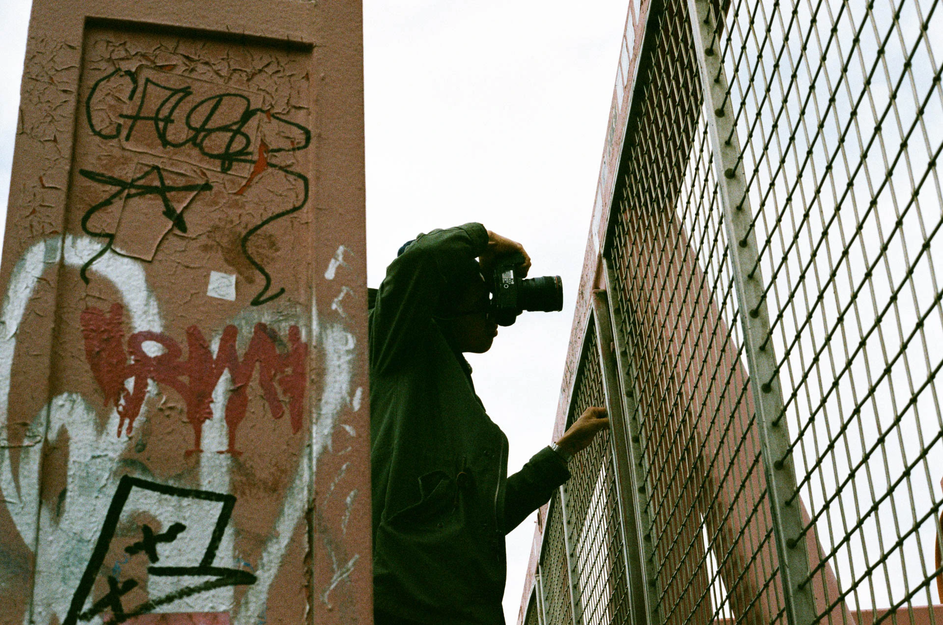 man photographing Williamsburg bridge on film