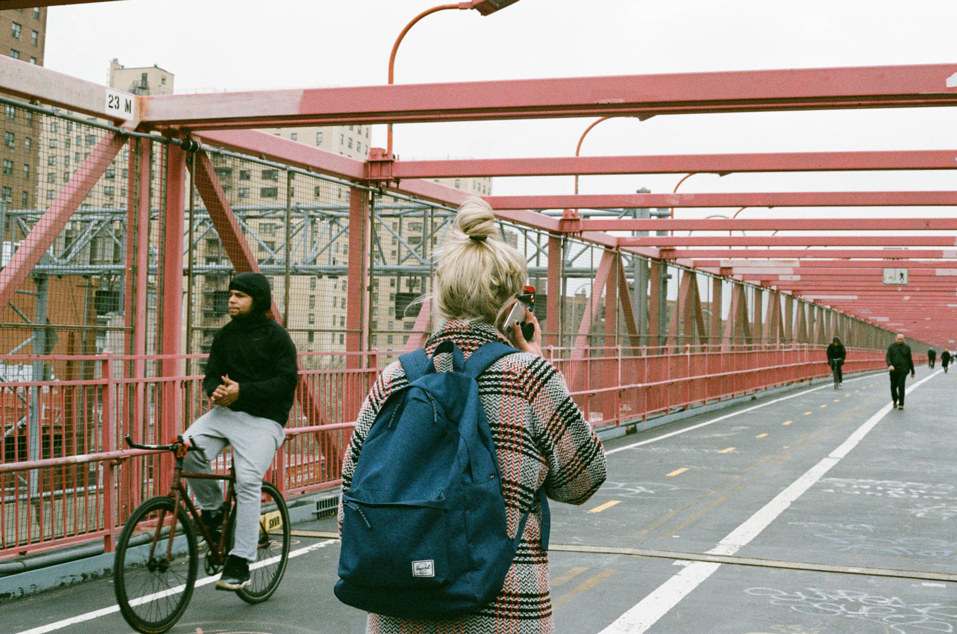 woman walking on Williamsburg bridge on film